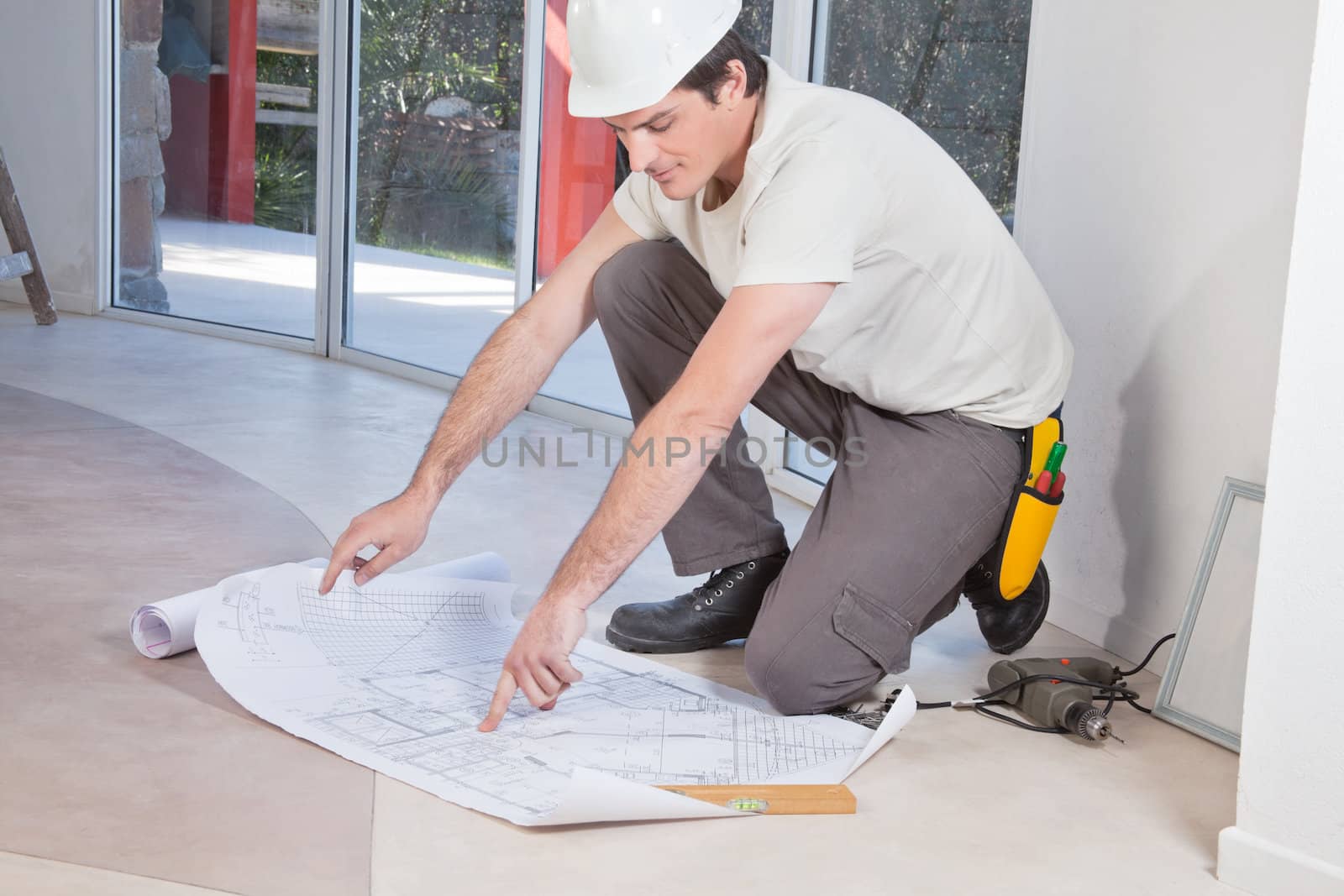 Man pointing at blueprint by leaf