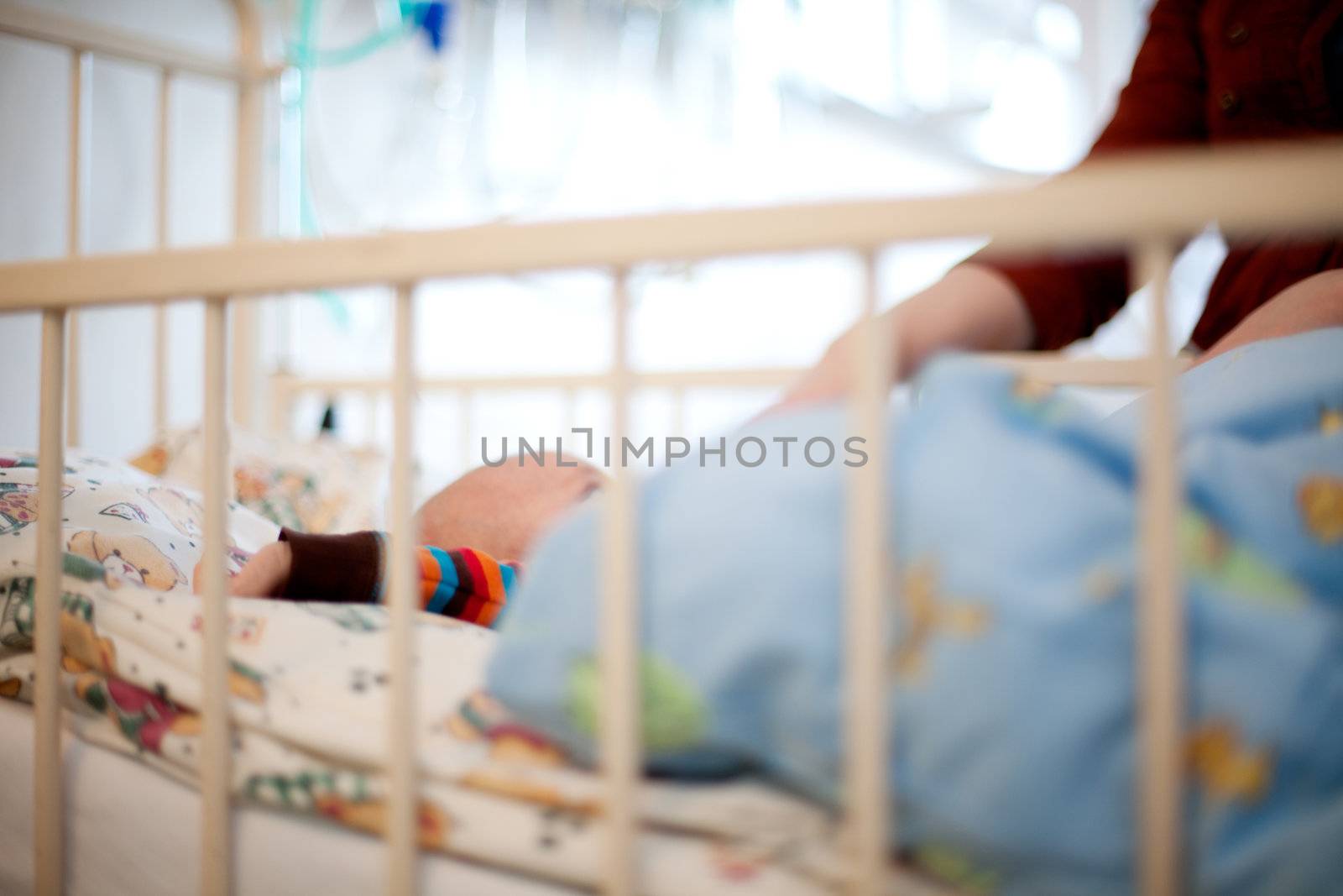 Abstract of a young baby in a hospital bed with mother beside