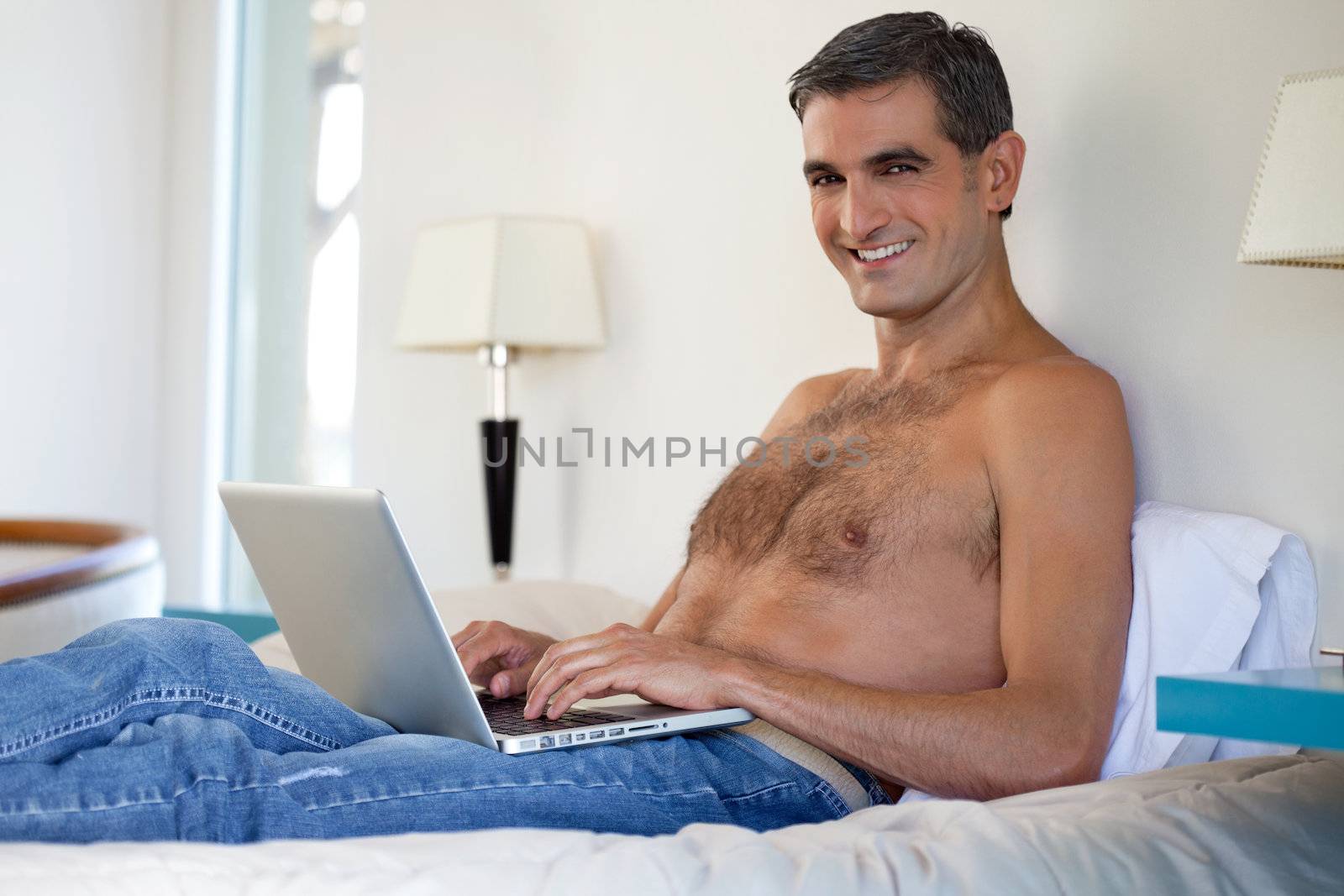 Shirtless Man Working on Laptop by leaf