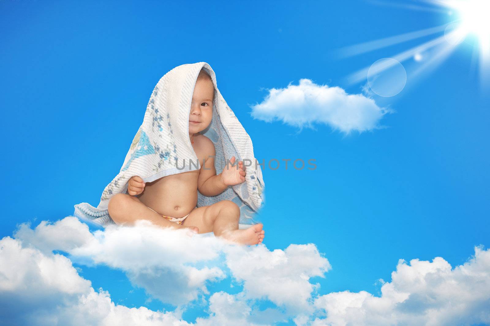 The small child sits on a white cloud in the sky