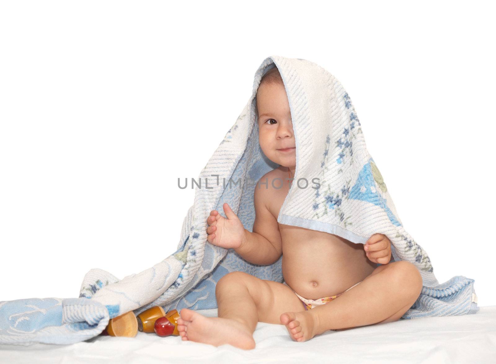 Beautiful baby looking out from under towel