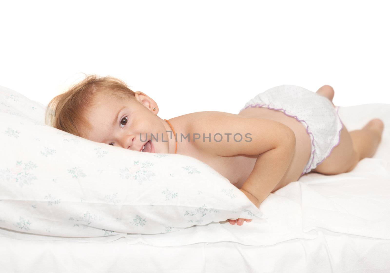 Beautiful baby lays on a white pillow
