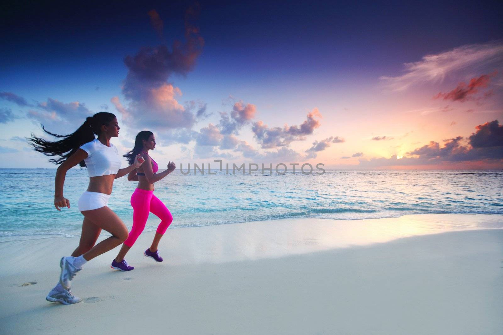 Two women running on beach by Yellowj