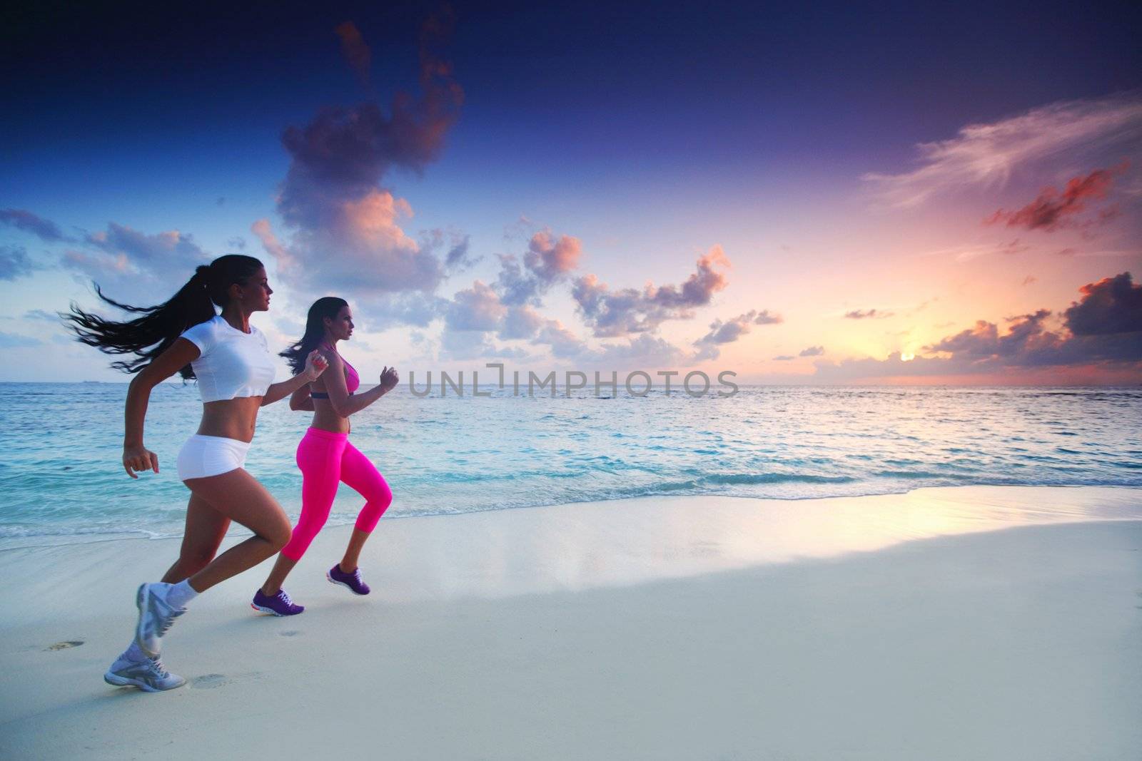 Fitness sport women running on beach at sunset