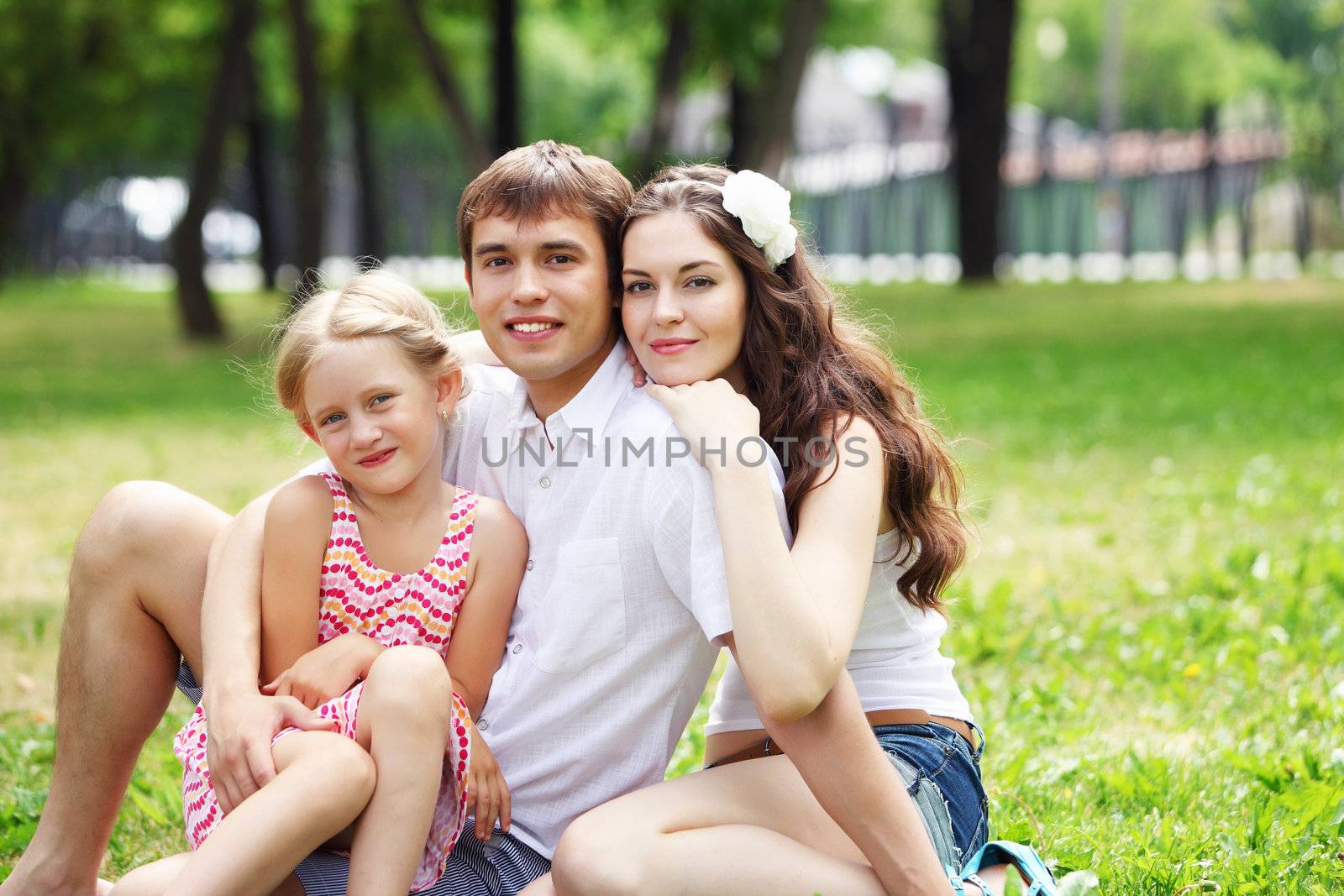 Young Family Outdoors on the grass in Park in summer