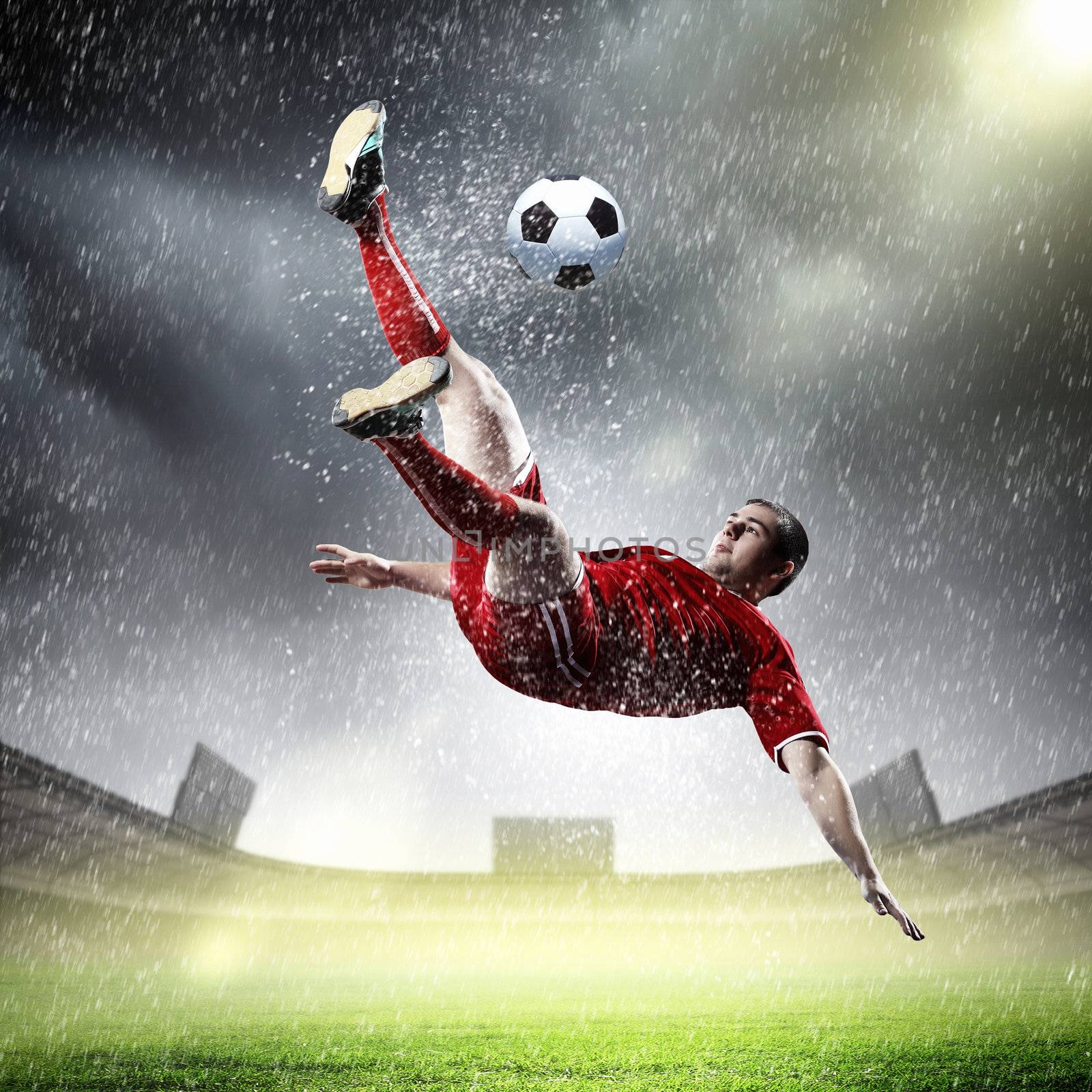 football player in red shirt striking the ball at the stadium under rain