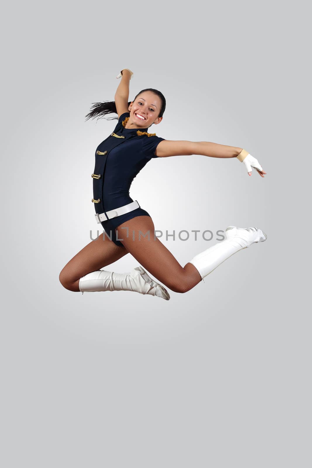 Young female dancer jumping against white background