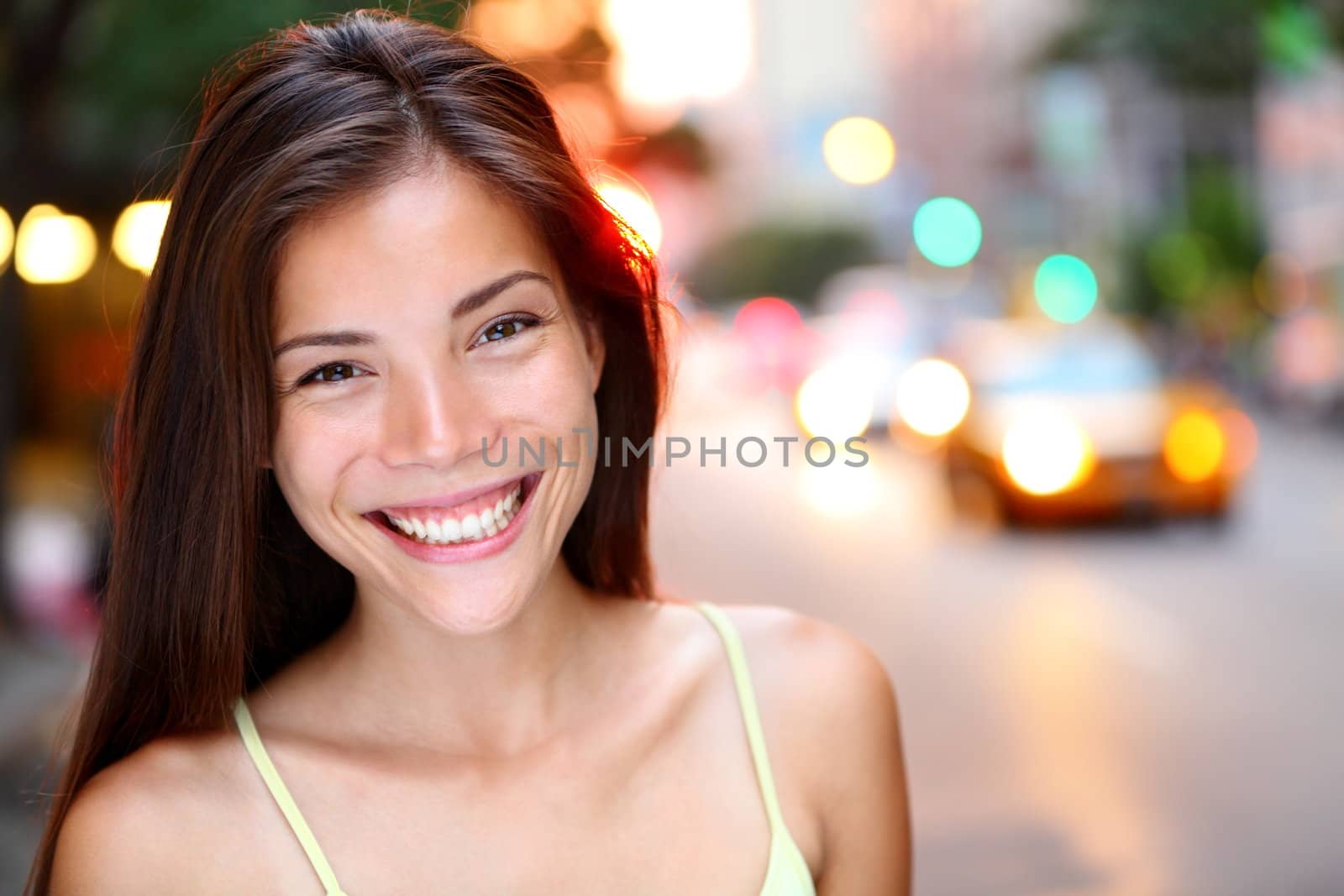 Asian woman portrait in New York City. Beautiful young mixed race Asian Chinese / Caucasian woman in her twenties smiling happy looking at camera.