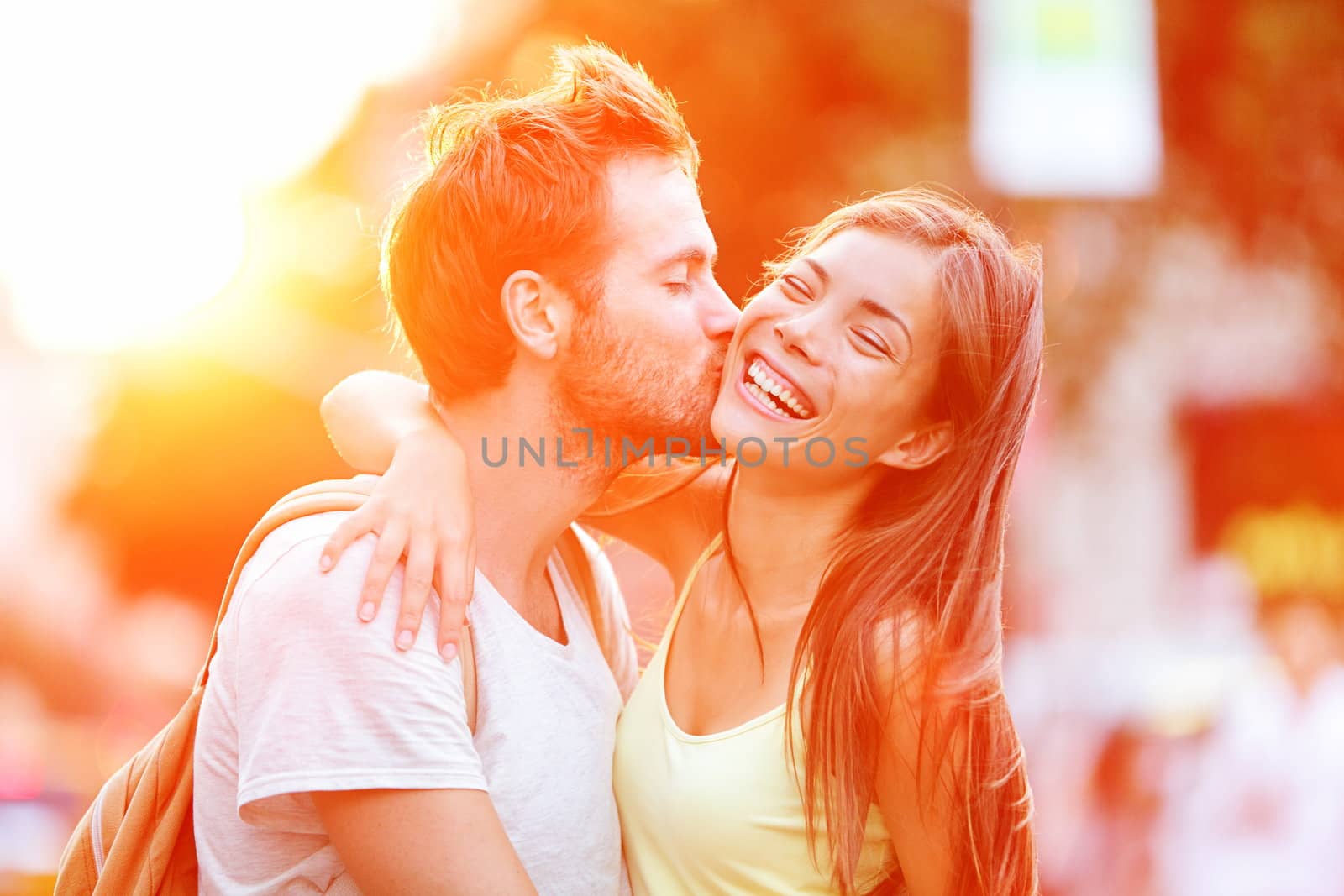 Couple kissing fun. Interracial young couple embracing laughing on date. Caucasian man, Asian woman on Manhattan, New York City, USA.