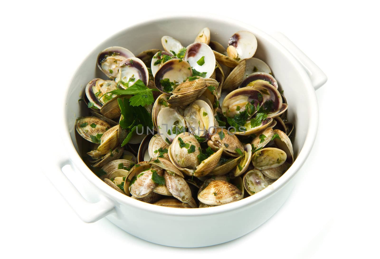 white bowl of clams soup with parsley on white background