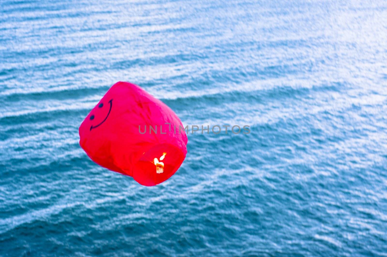 An image of red hot air balloon over the sea