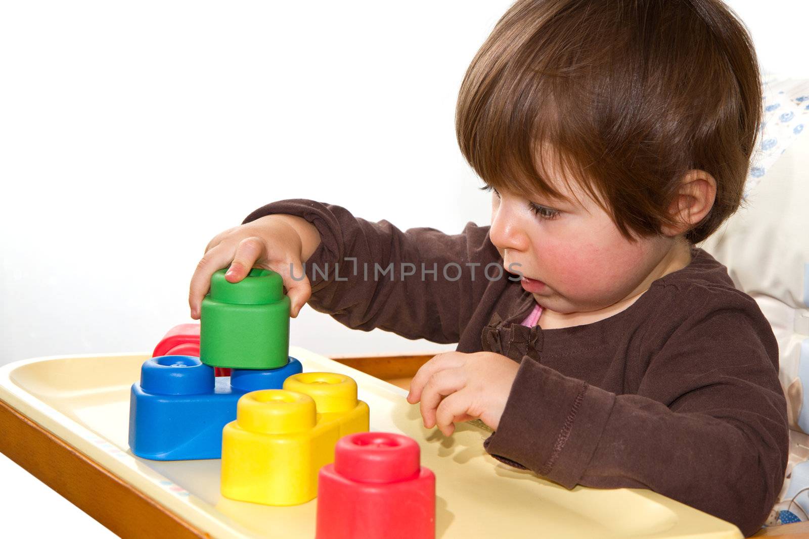 little girl playing with colorful blocks by lsantilli