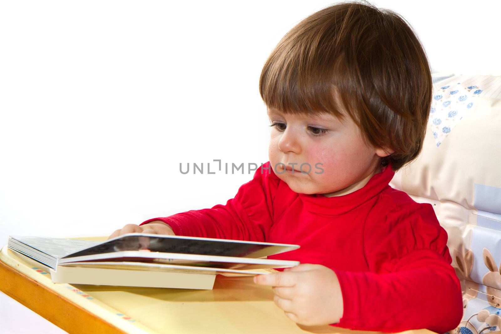 adorable one-year old baby reading a book by lsantilli