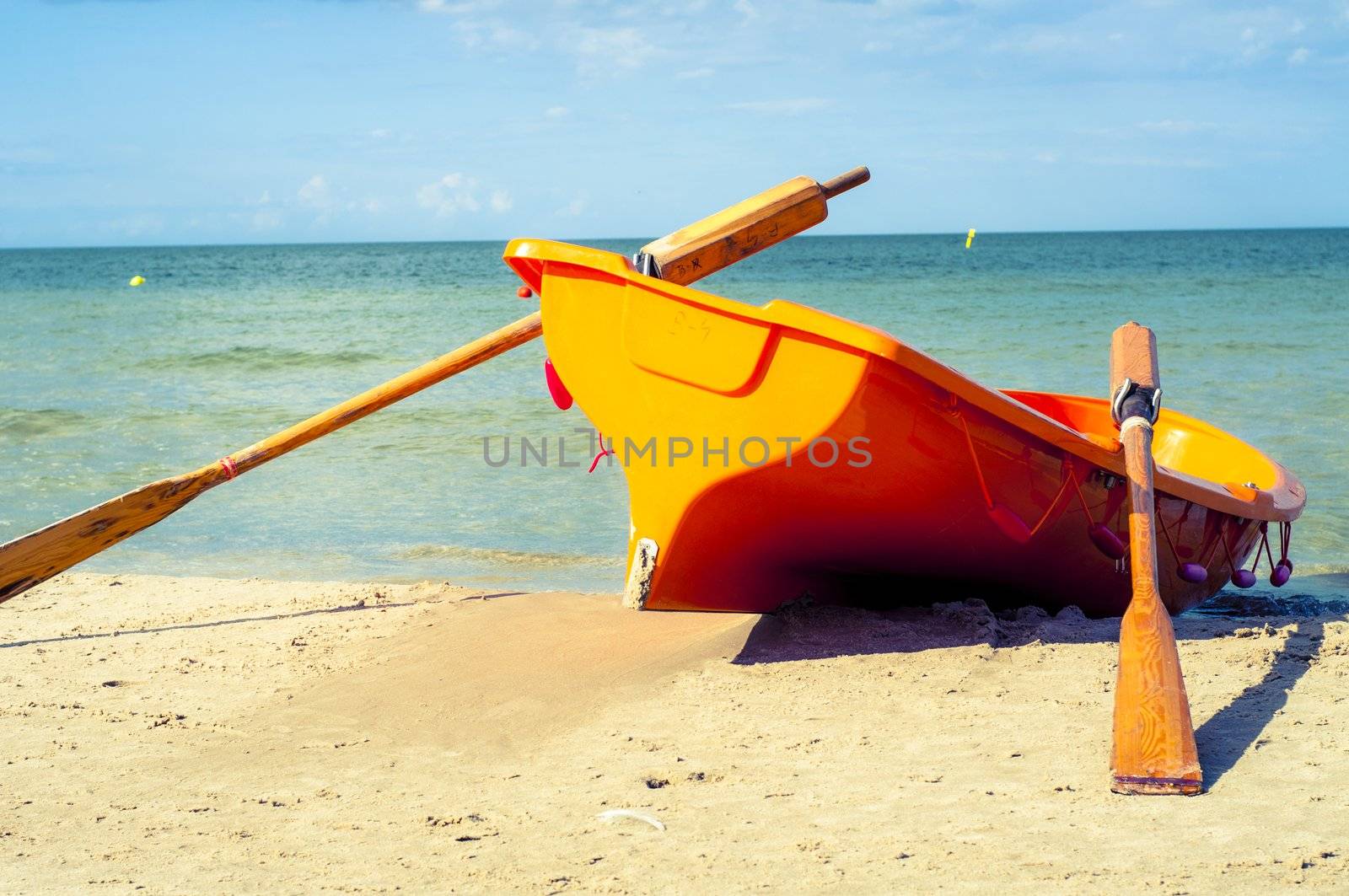 An image of orange rescue boat on the beach of baltic sea