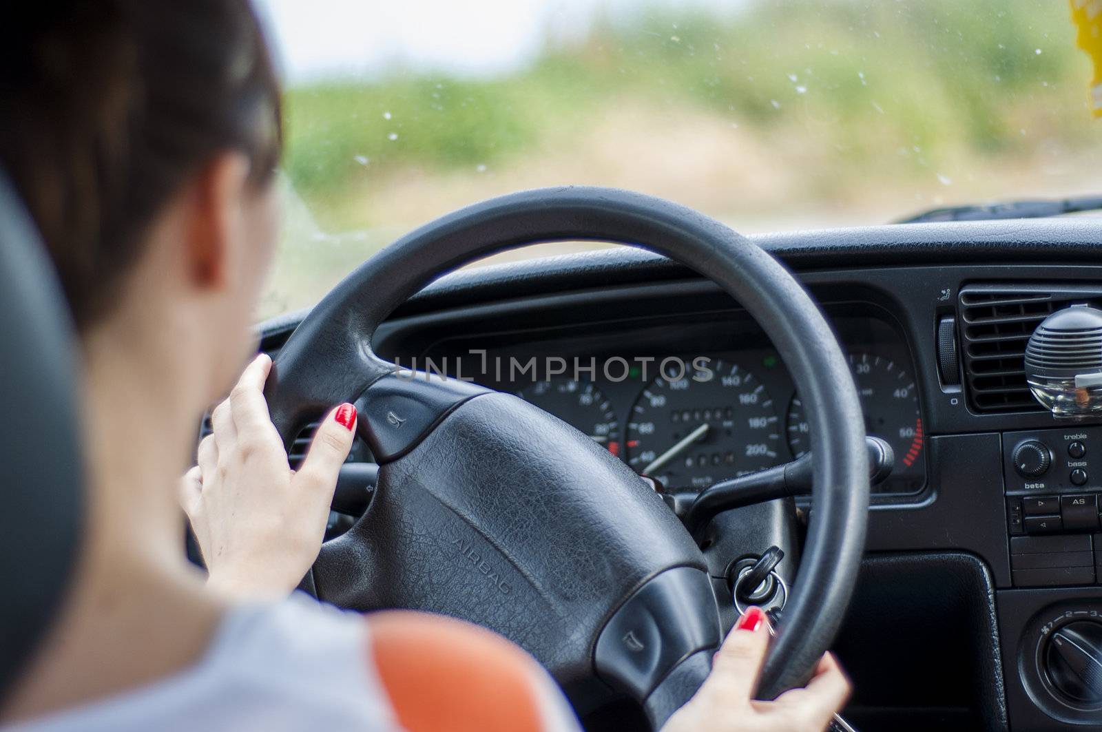 Hands of a female driver on steering wheel