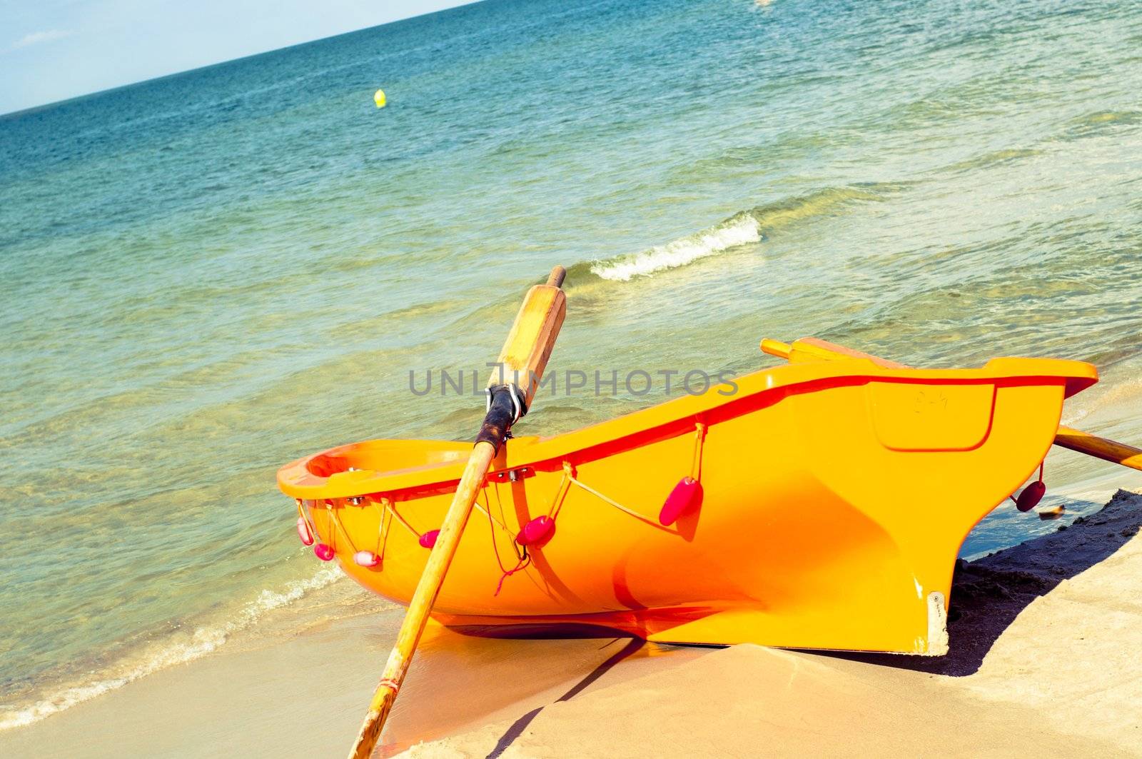 An image of orange rescue boat on the beach of baltic sea