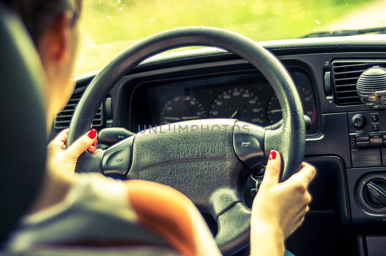 Hands of a female driver on steering wheel