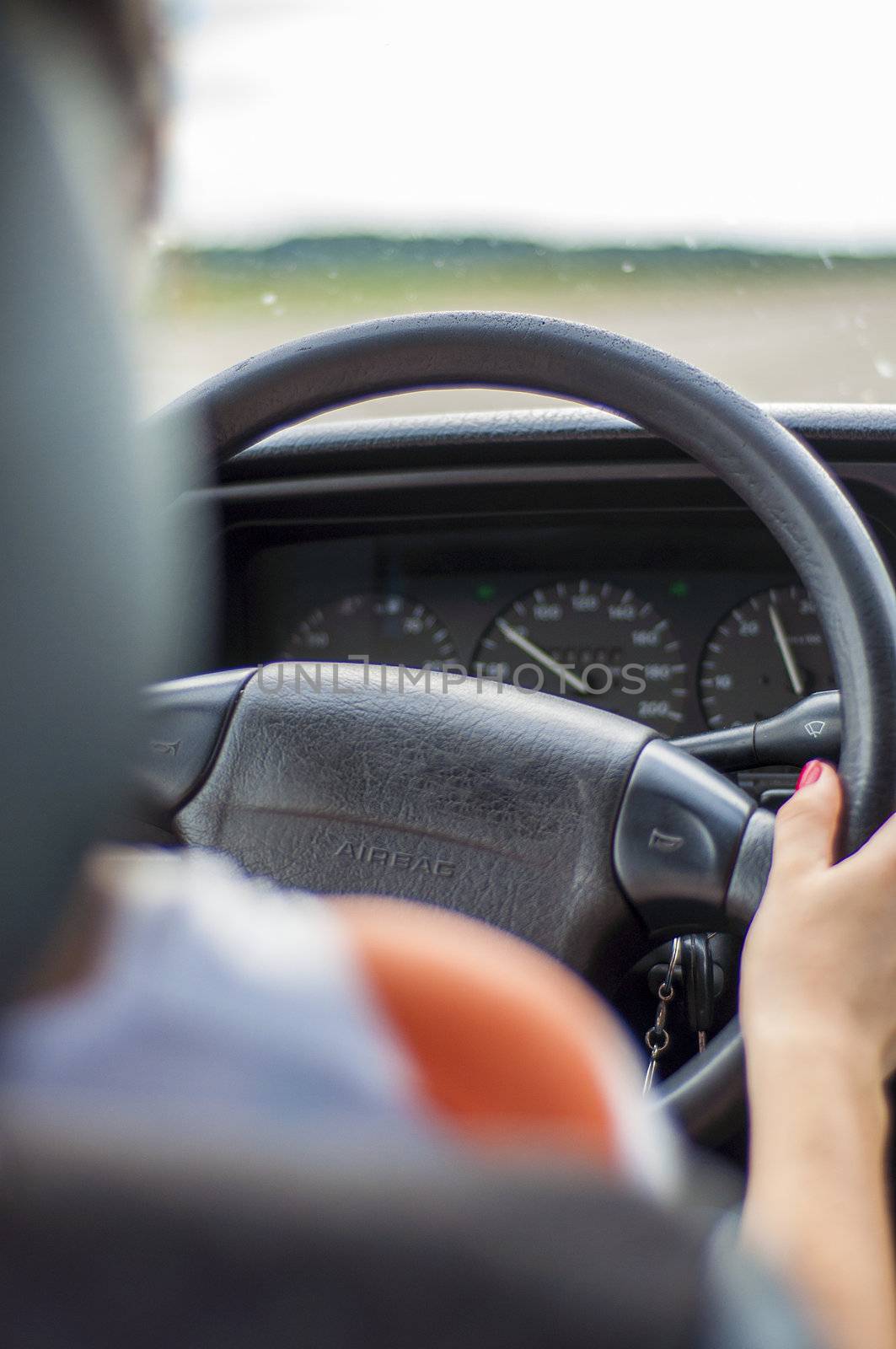 Hands of a female driver on steering wheel