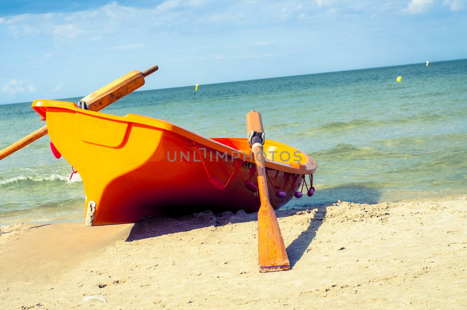An image of orange rescue boat on the beach of baltic sea