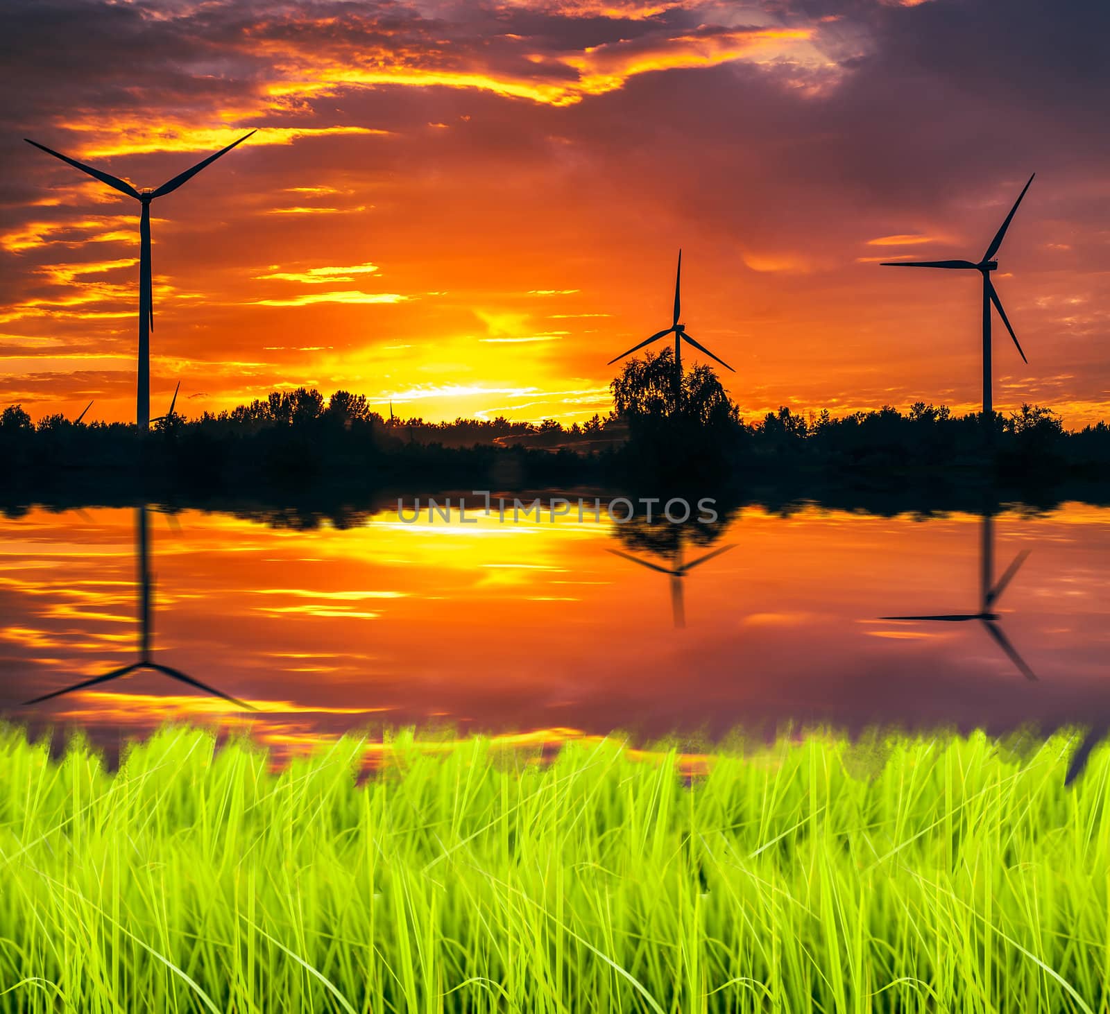 A silhouette of windturbines on a amazing sunset