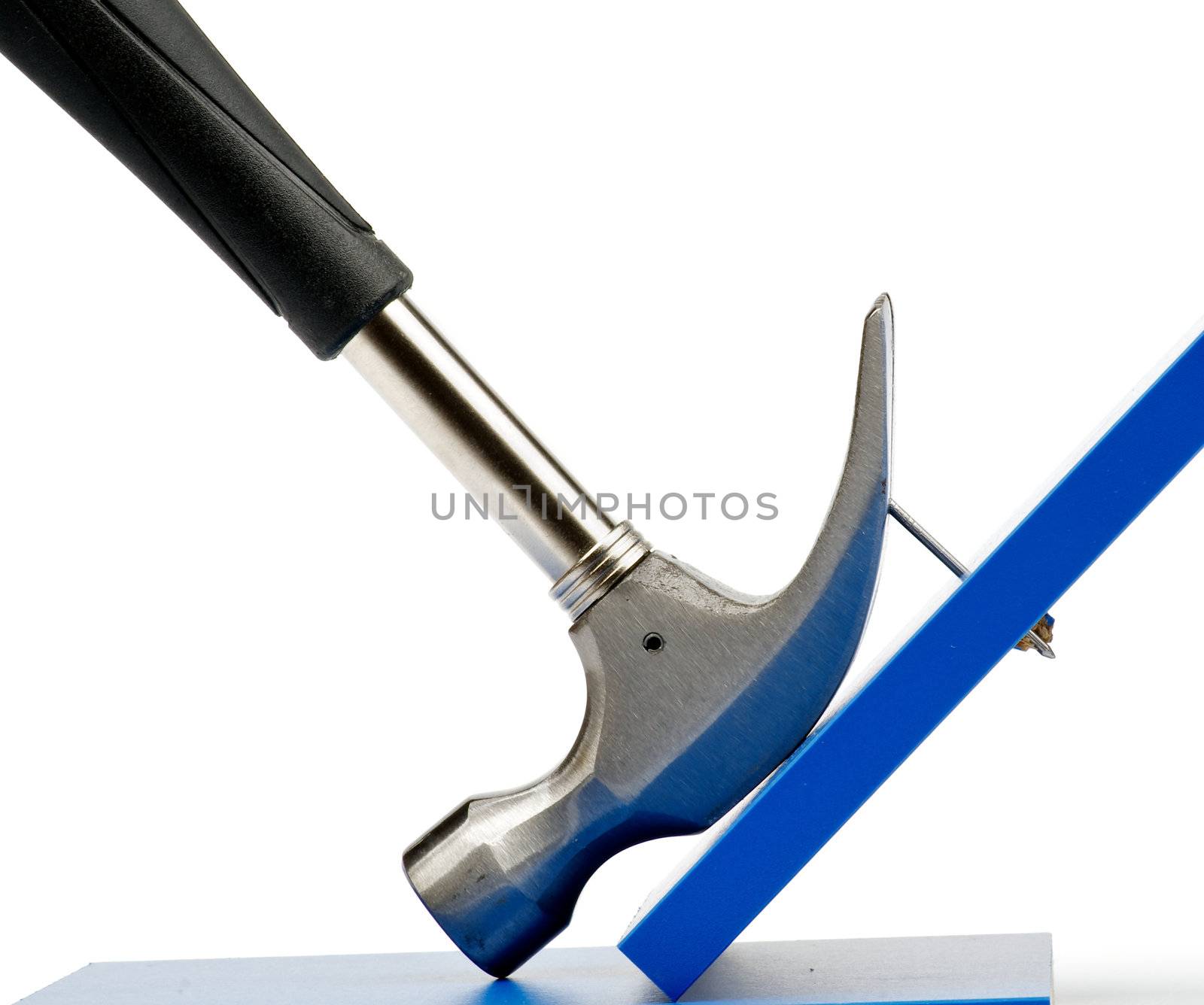 Hammer Pulling Nail Out of Blue Plank closeup on white background