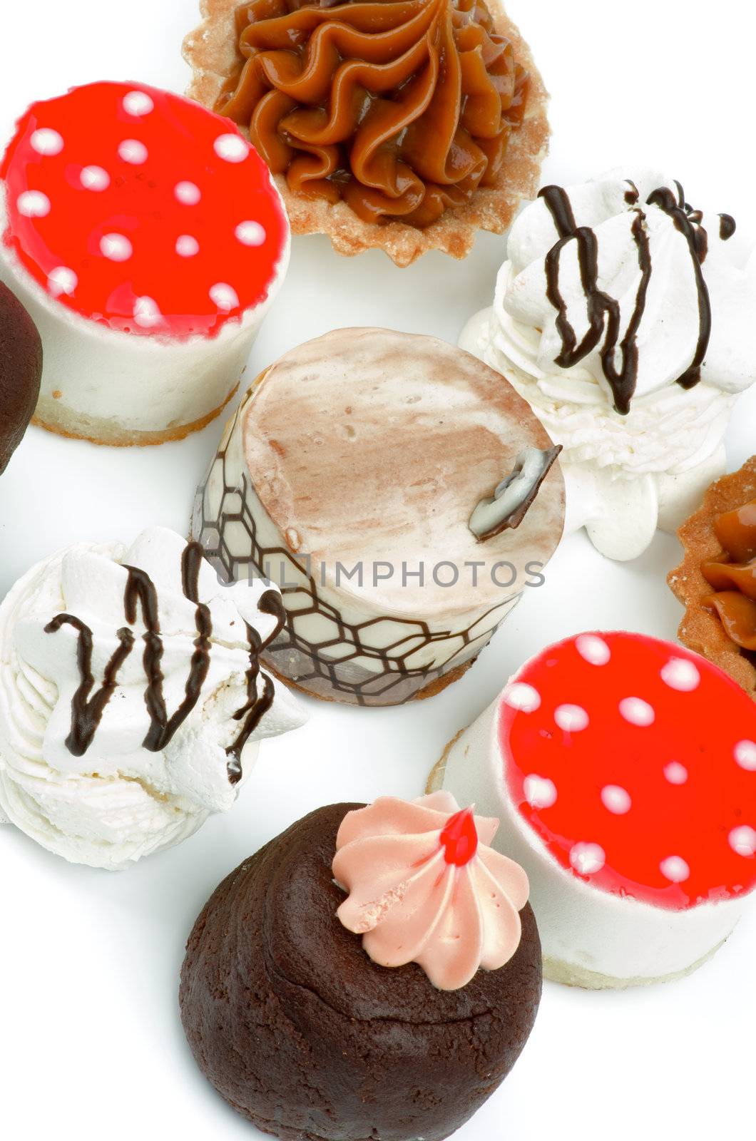 Arrangement of Cakes with Chocolate Cupcakes,  Tartlet, Strawberry Jelly Cheesecake Polka Dot, Dark Chocolate Glazed Meringue and Sponge Cake closeup on white background