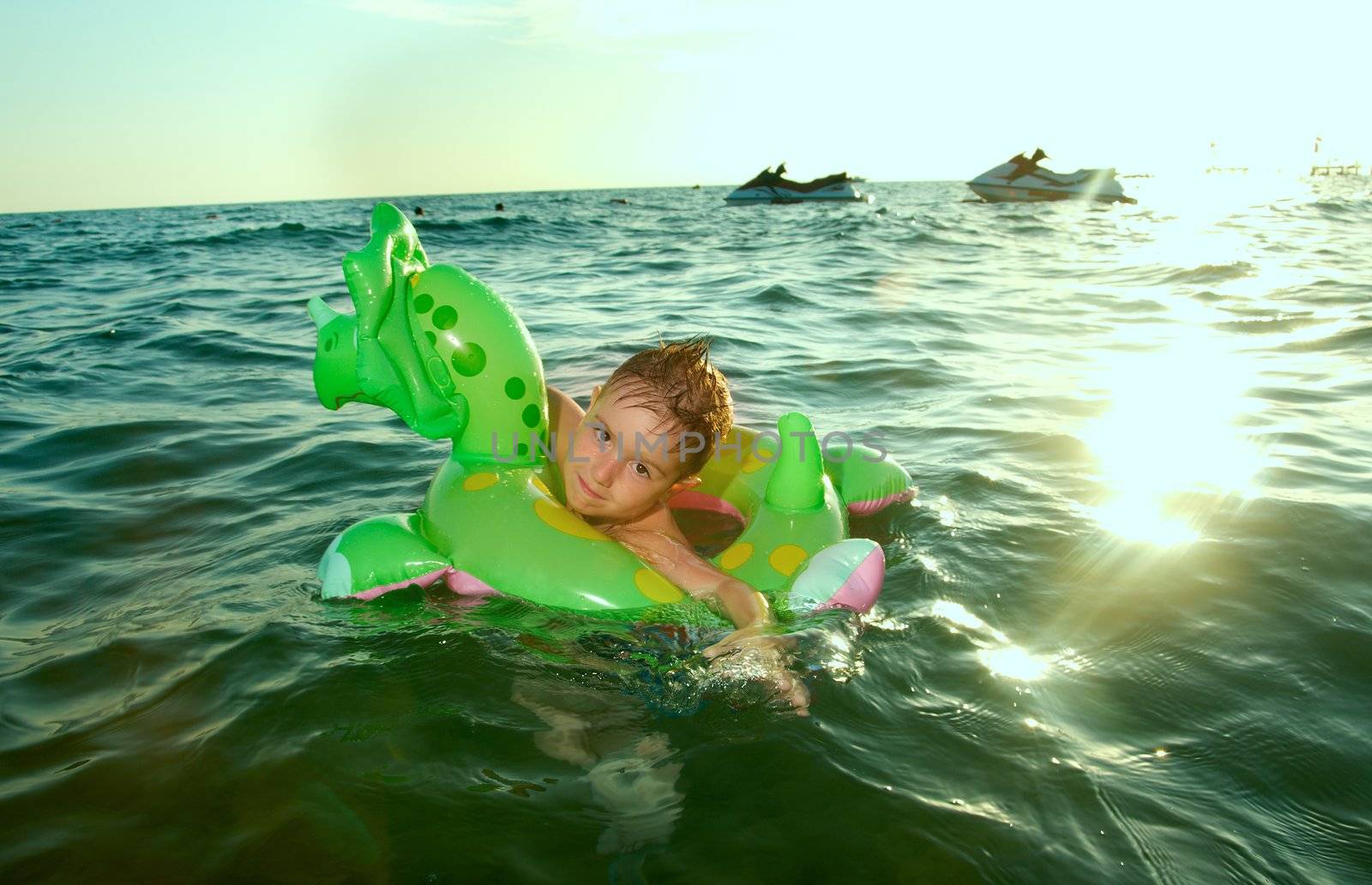 Little boy in the waves on the sea beach