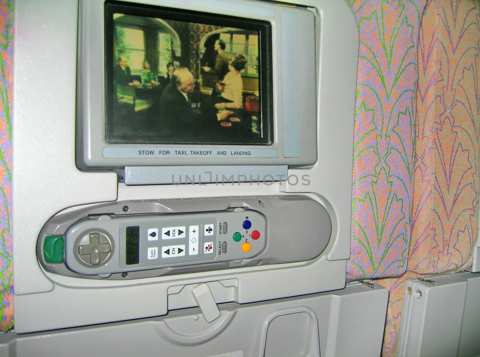 TV set with remote control on the airplane seat.