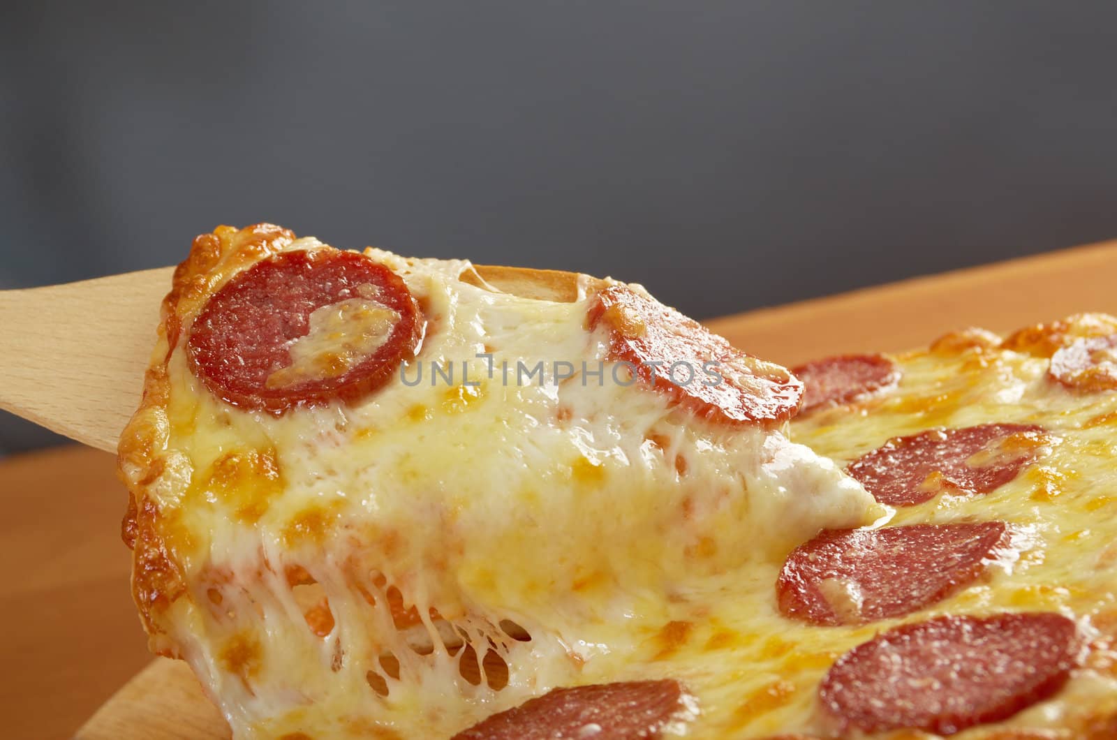 homemade pizza  Pepperoni .taking slice of pizza,melted cheese dripping.