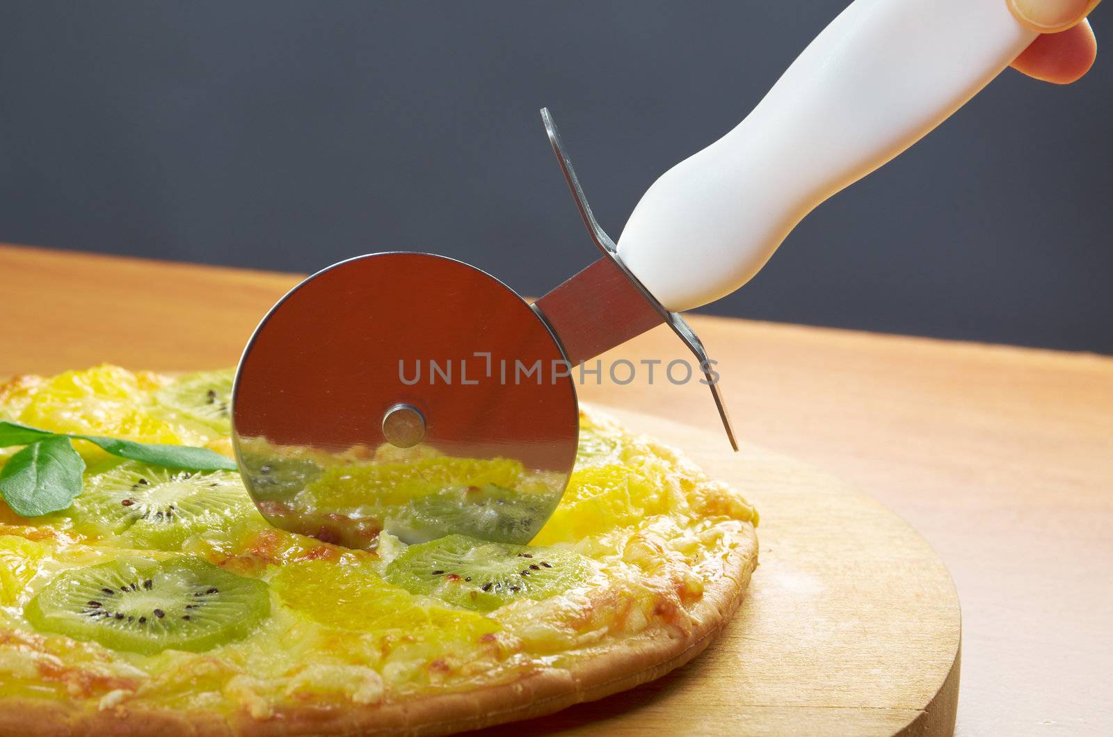 homemade sweet pizza with fruit.Closeup  a knife cut the pizza 