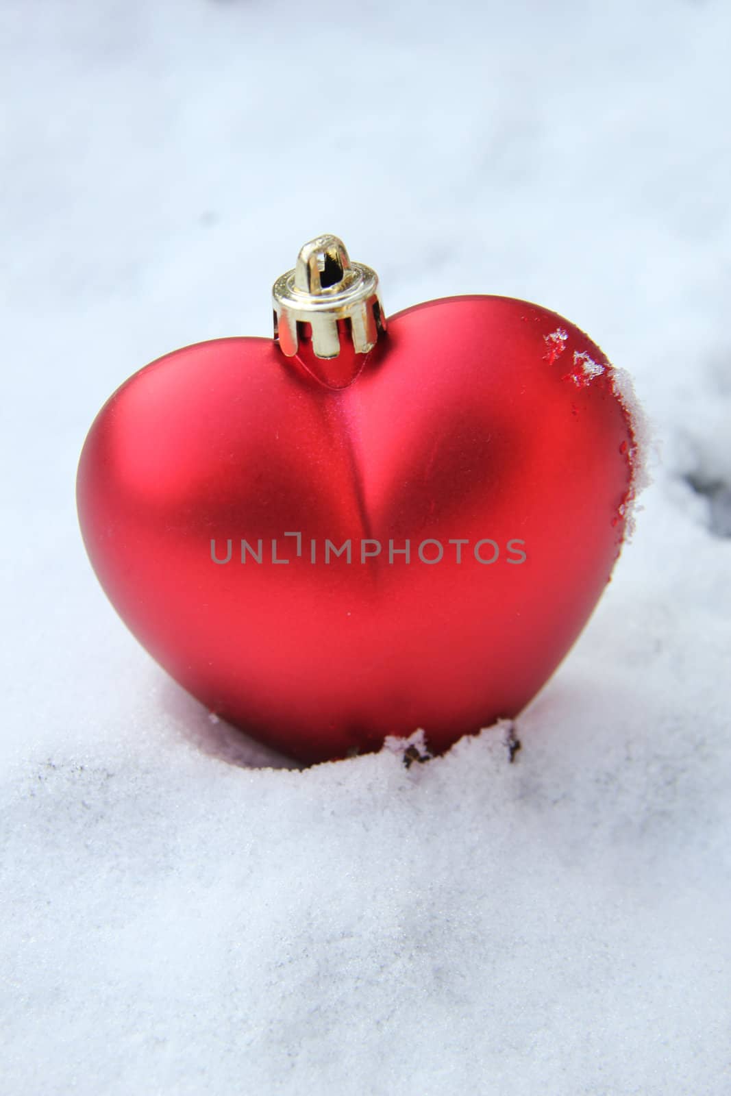 Heart shaped ornament in the snow by studioportosabbia