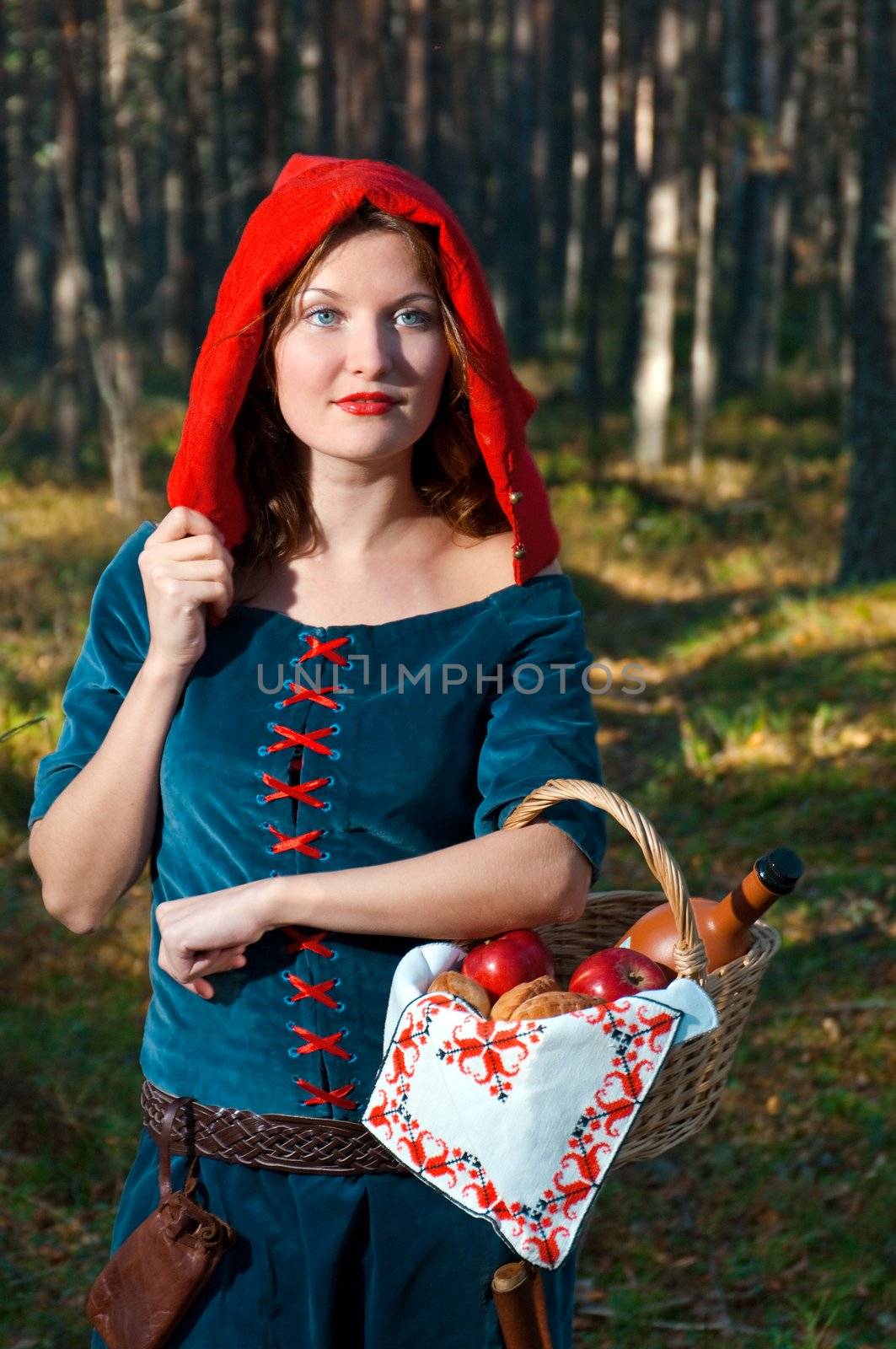 red Riding  hood standing in a wood . beautiful girl in medieval dress