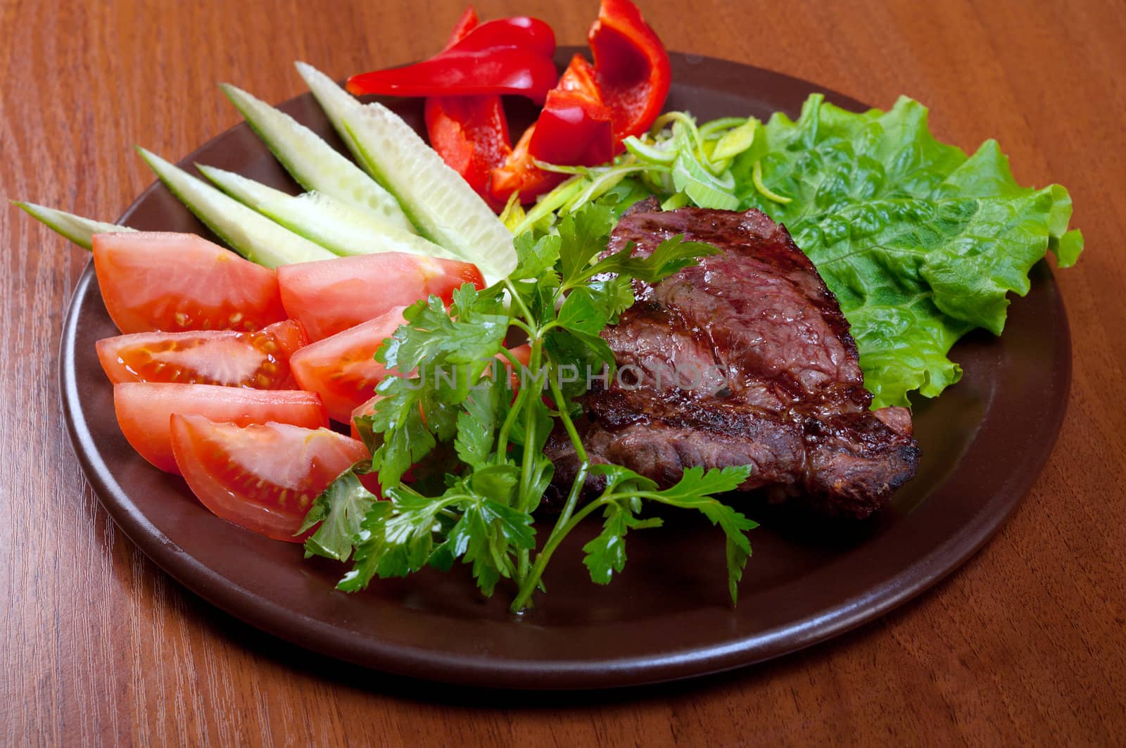 Grilled beef on white plate  with vegetable.closeup