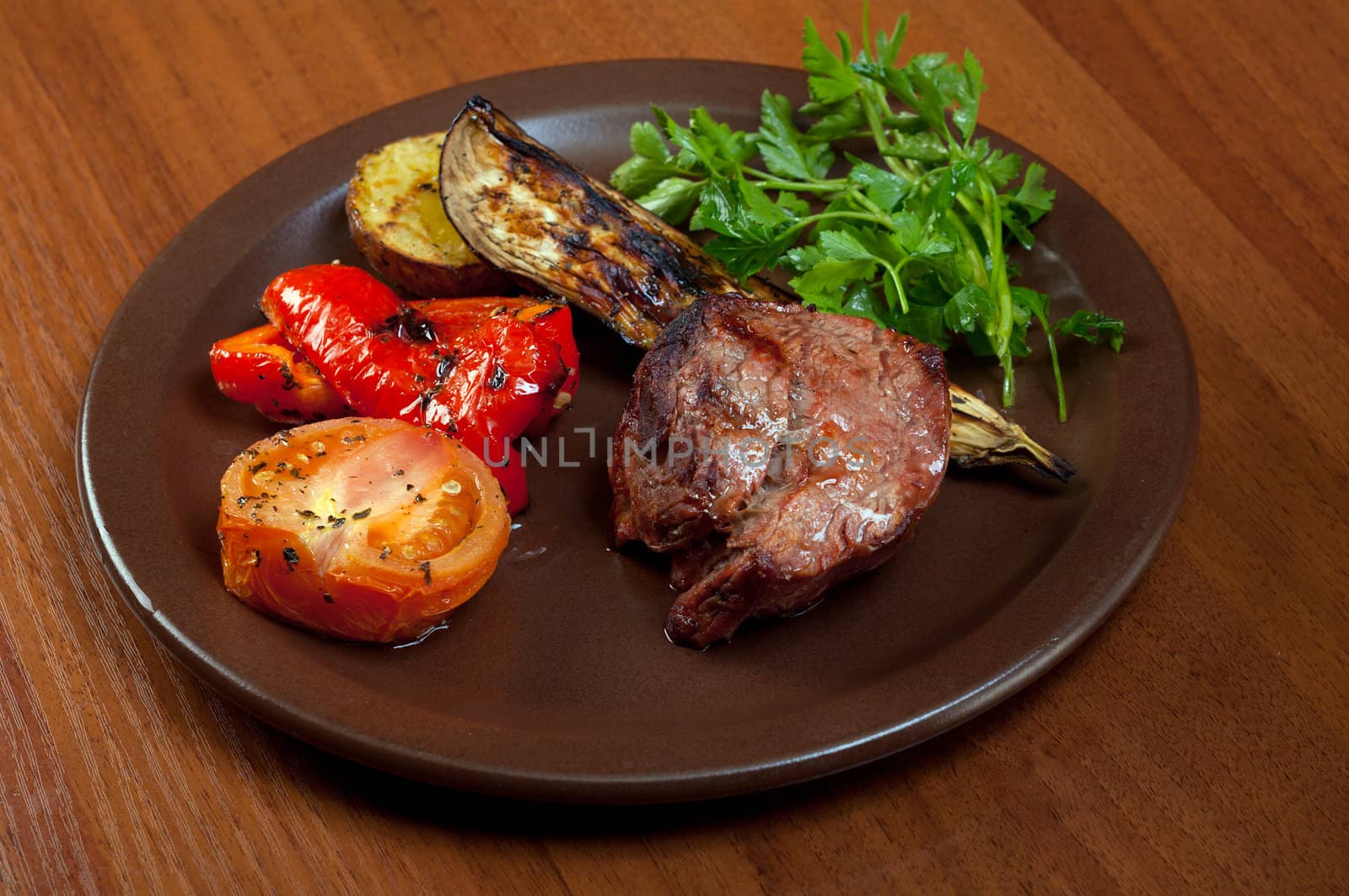 Grilled beef on white plate  with vegetable.closeup