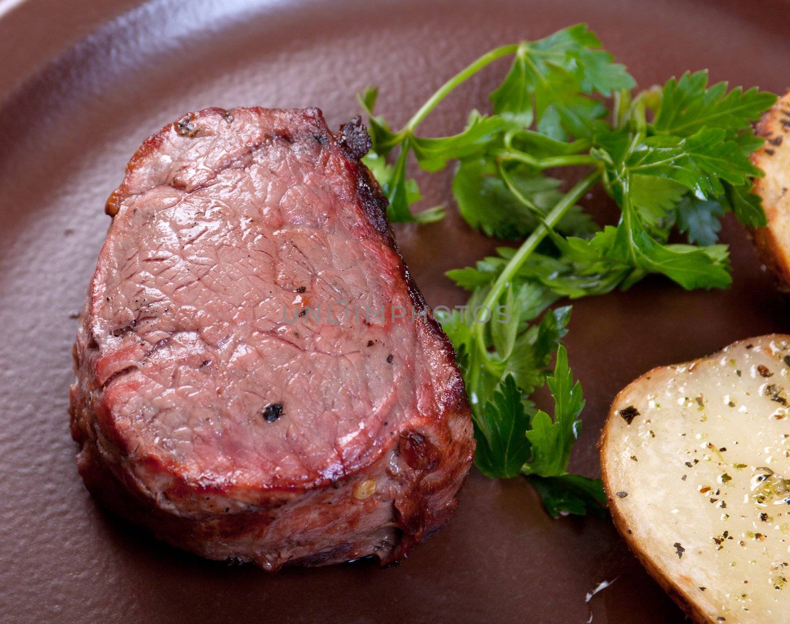 Grilled beef on white plate with potatoes salad and tomatoes  .Shallow depth-of-field. 