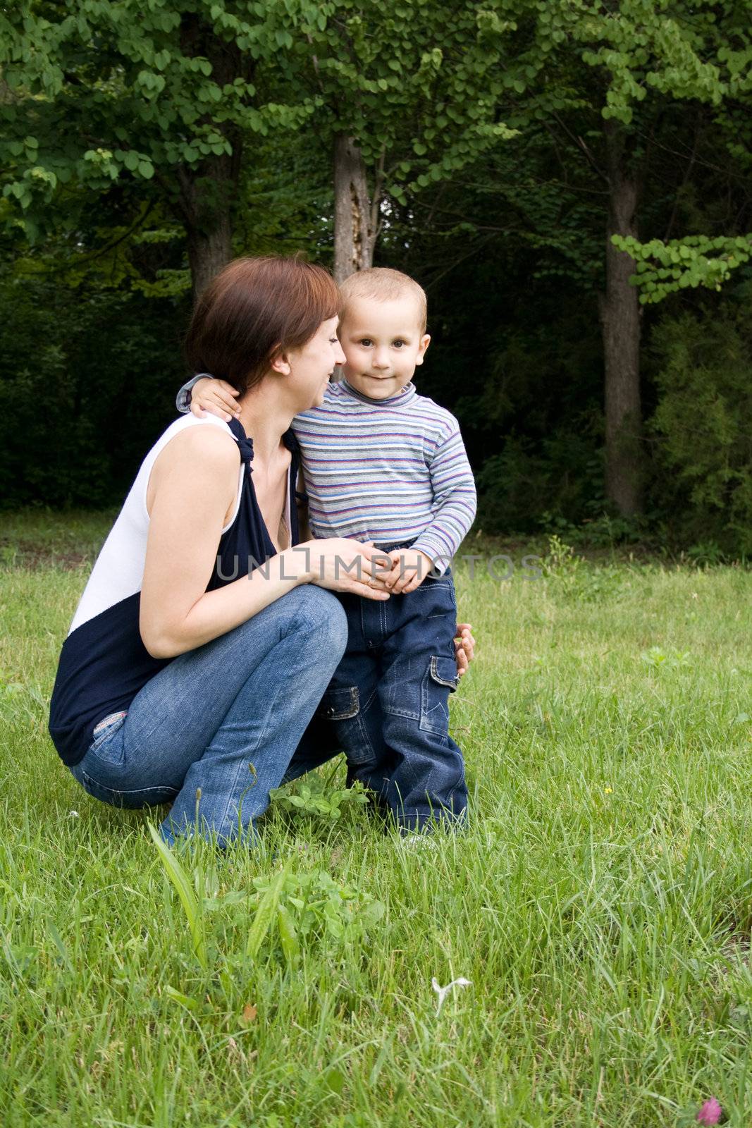child with his mother played on green grass