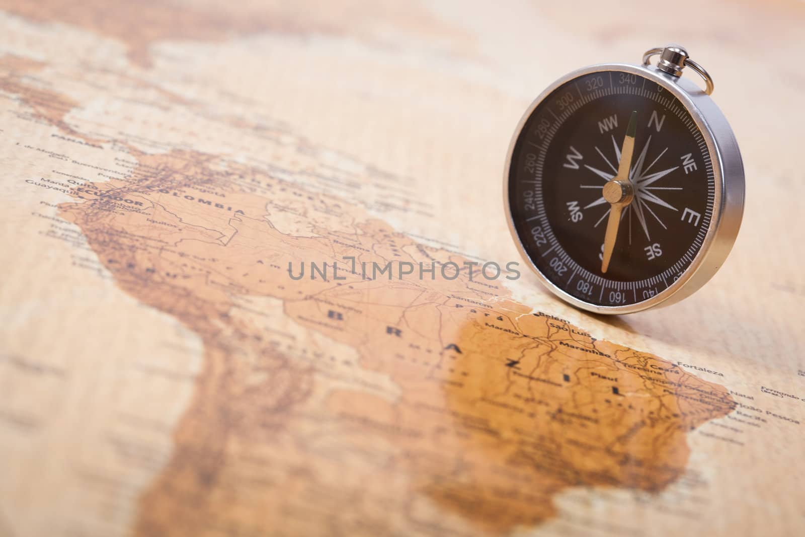 A photograph with shallow depth of field of a black compass on a map, with selective focus.