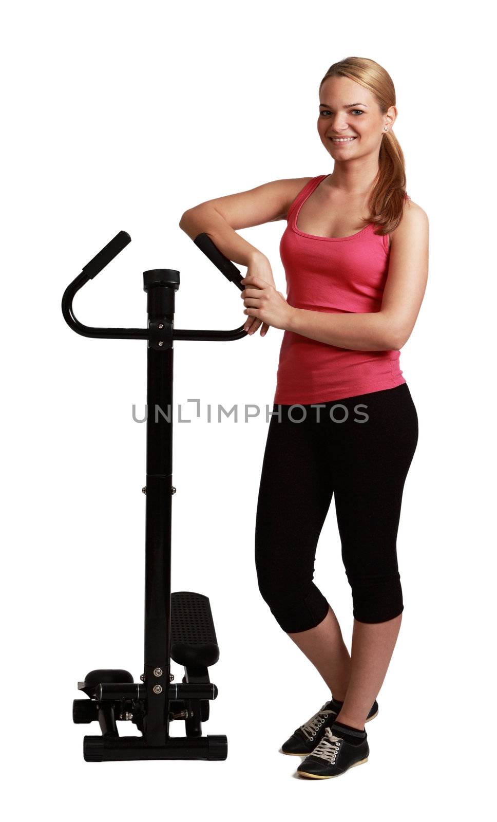 Young blonde woman standing near a stepper against a white background.