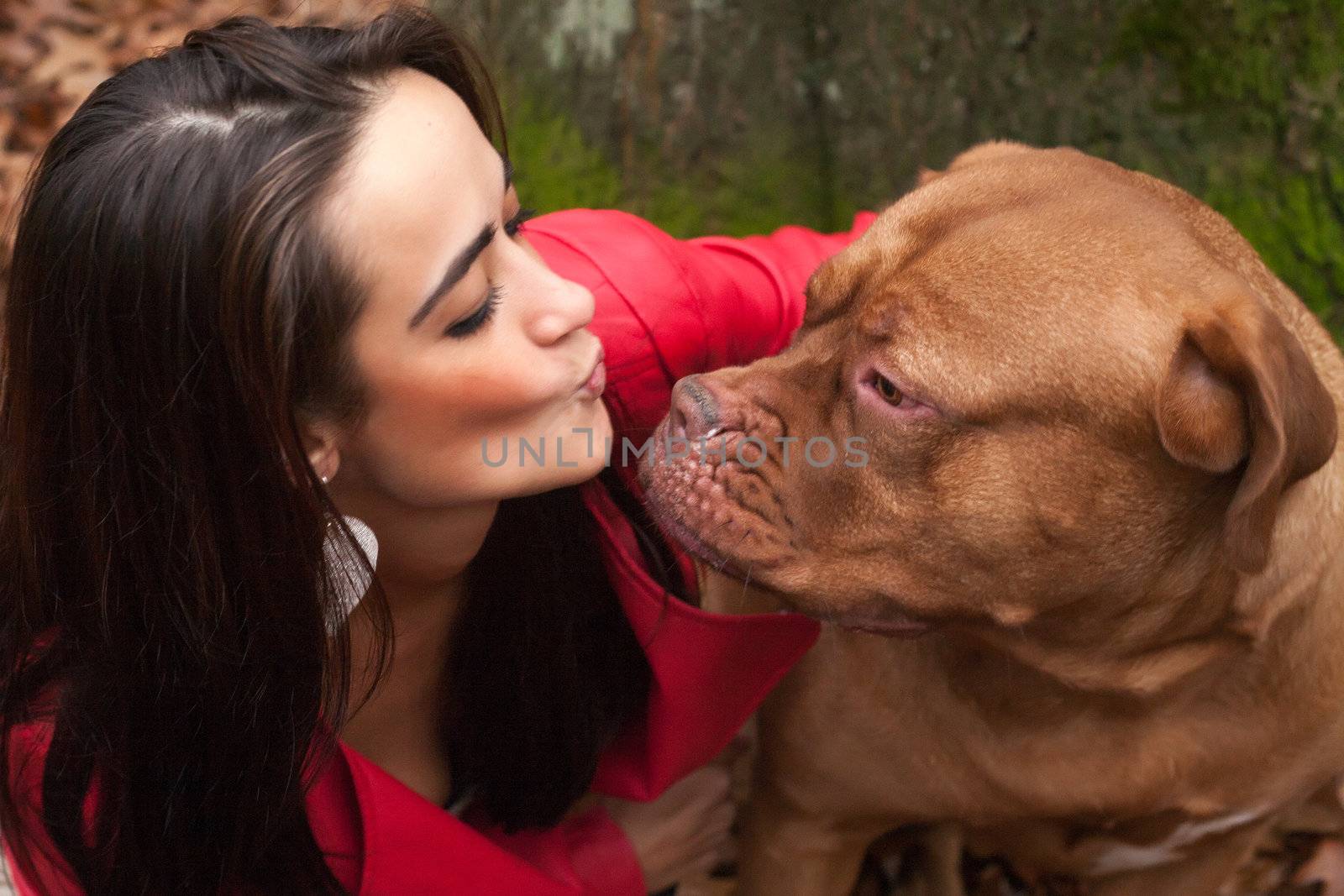 Young woman is having fun with her dog in the forest