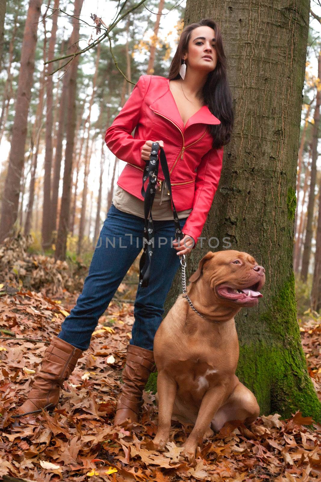 Young woman is having fun with her dog in the forest