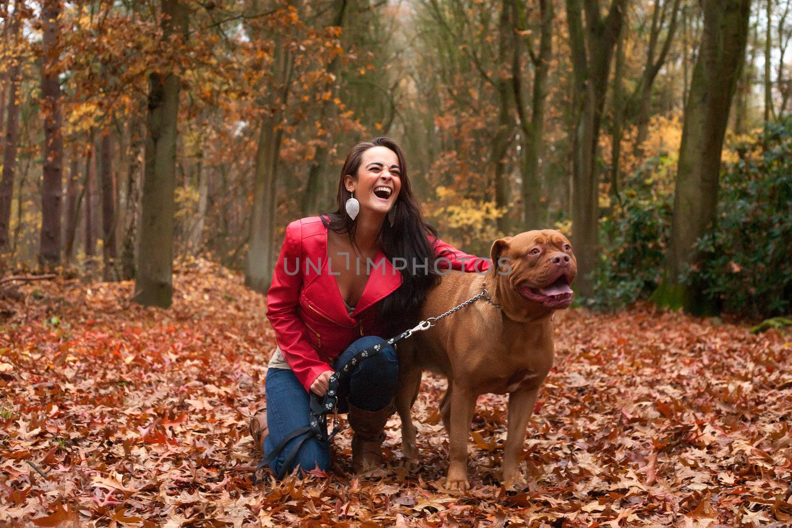 Young woman is having fun with her dog in the forest