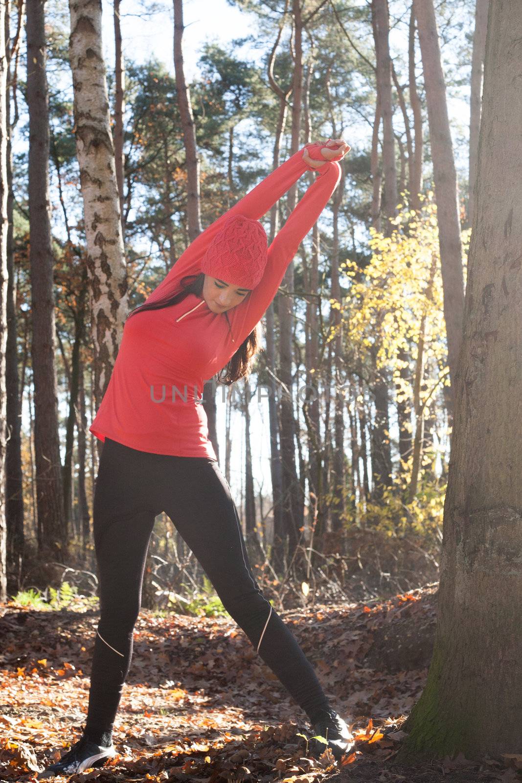 Young woman is working on her body in the forest