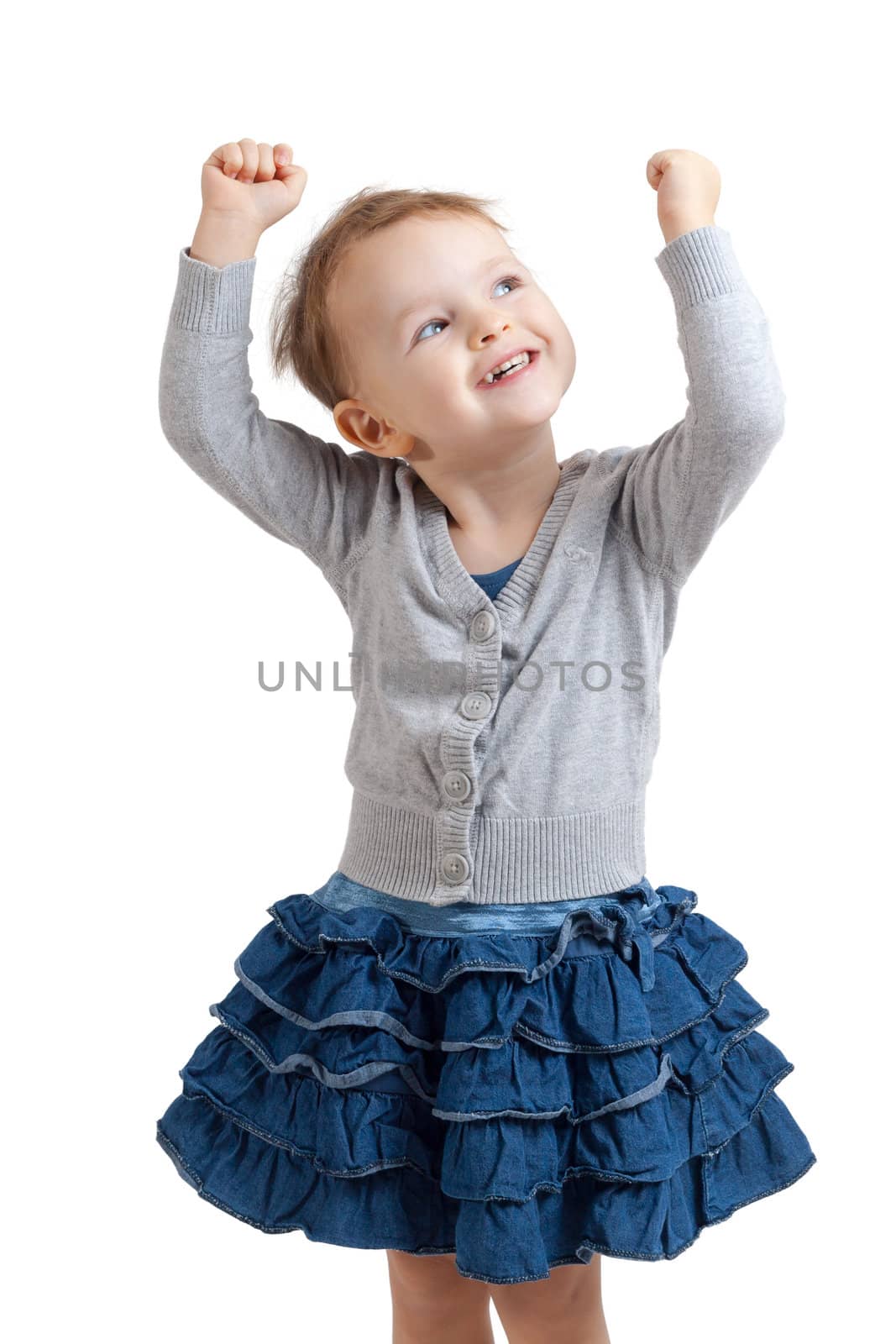 portrait of an smiling little blonde girl wearing a blue skirt holding up her hands - isolated on white background