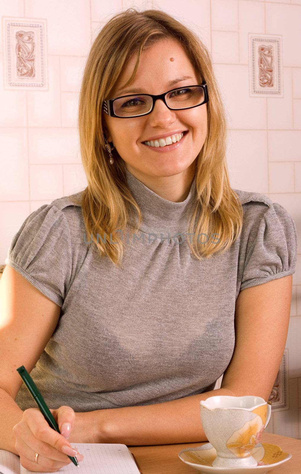 An attractive professional businesswoman, writing notes and jotting down items in a notebook..
