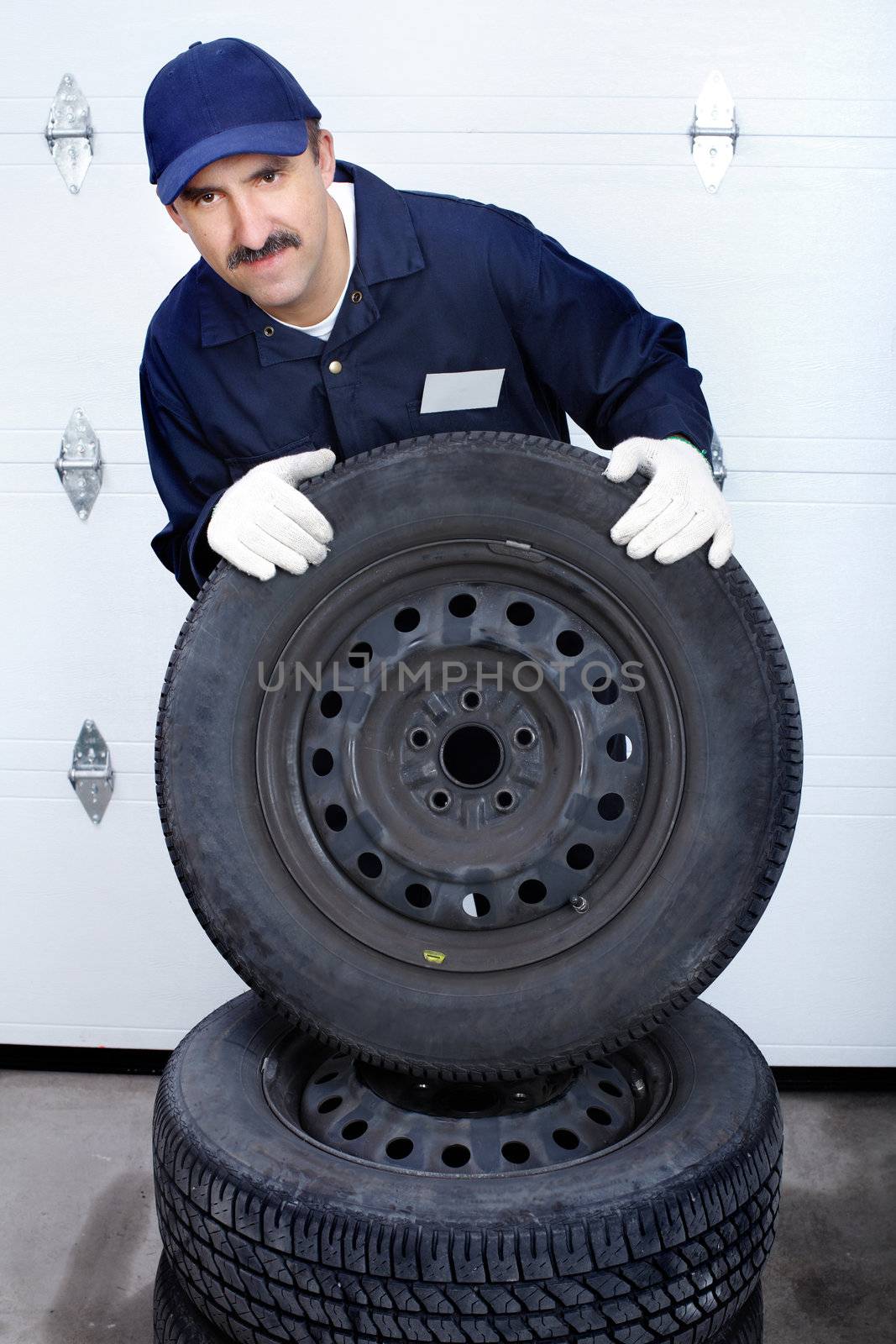 mechanic man with auto wheels. Worker. Business