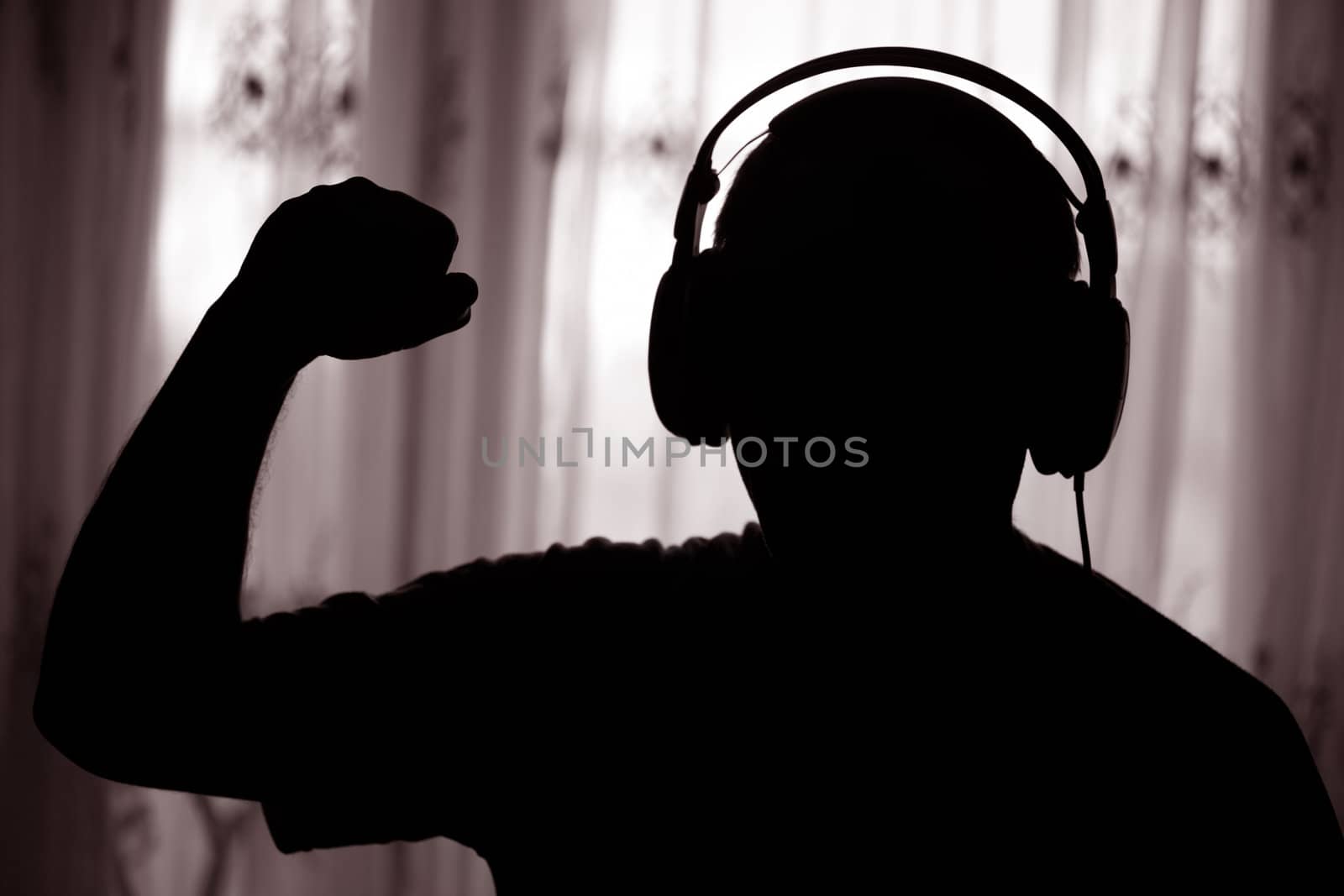 The man listens to music in a dark room