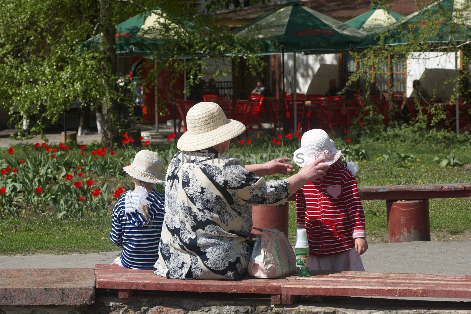 The grandmother with two girls have a rest in park