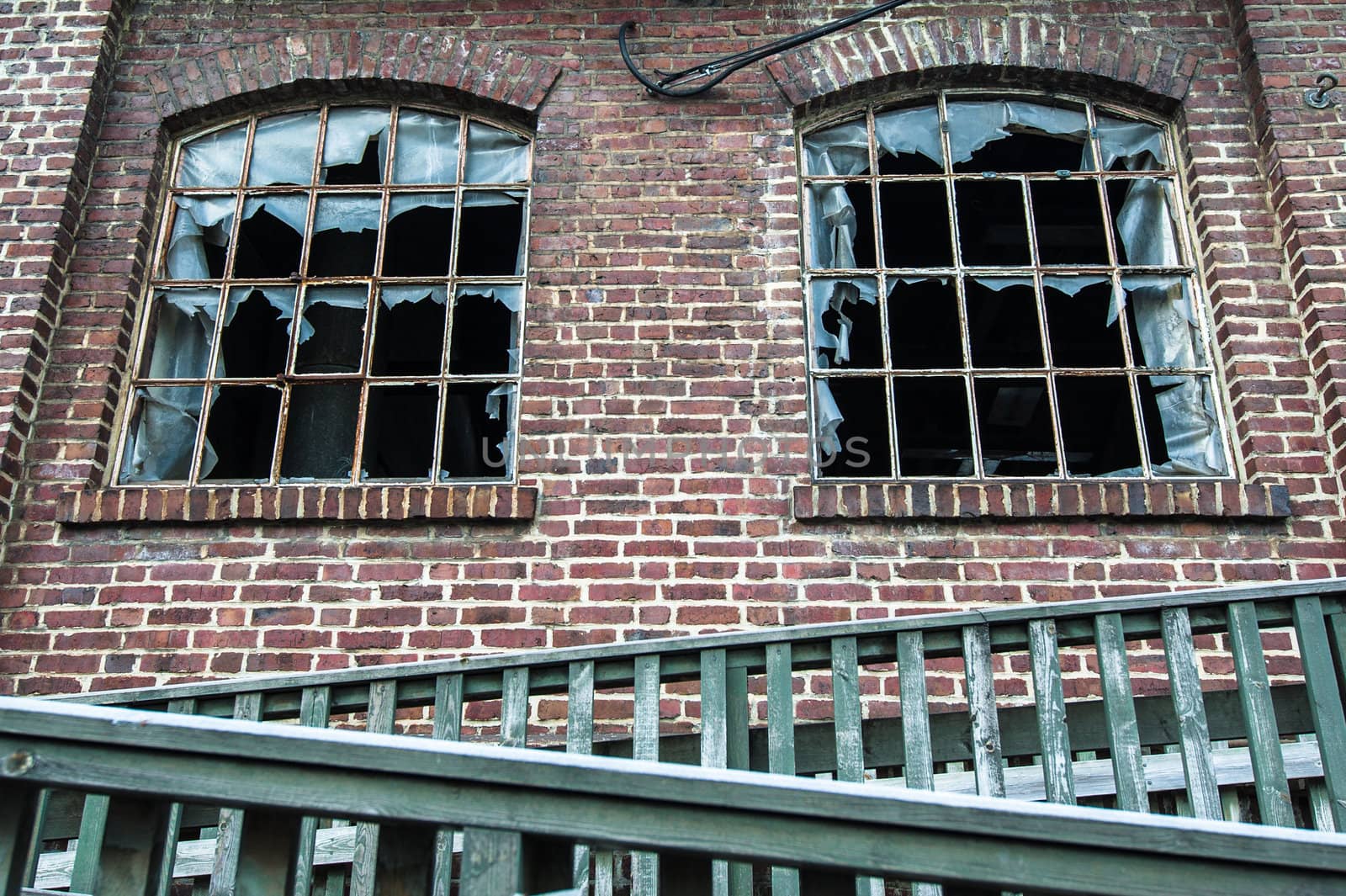 Two old broken windows in old worn down building