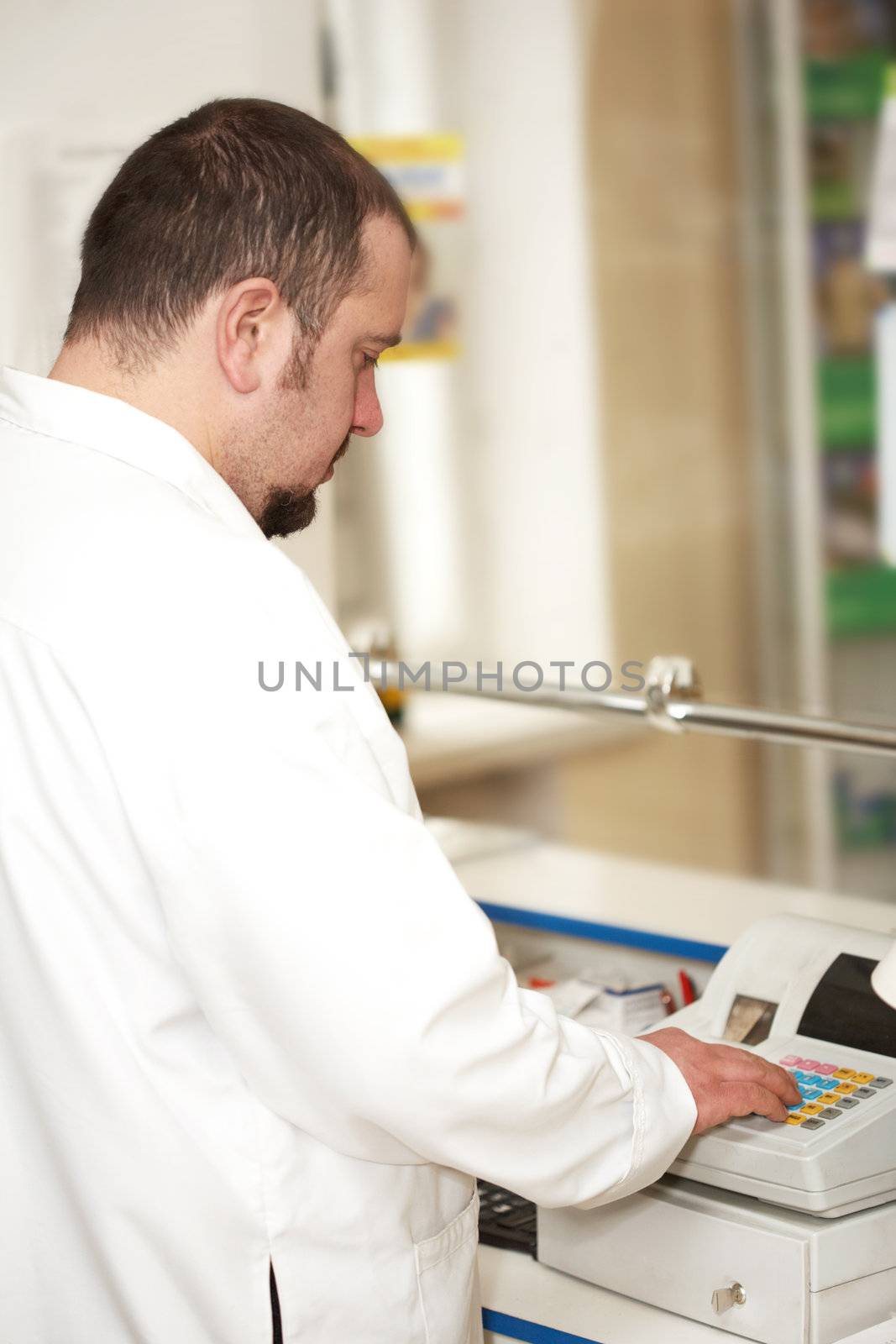 Portrait of a male pharmacist at pharmacy. Selling