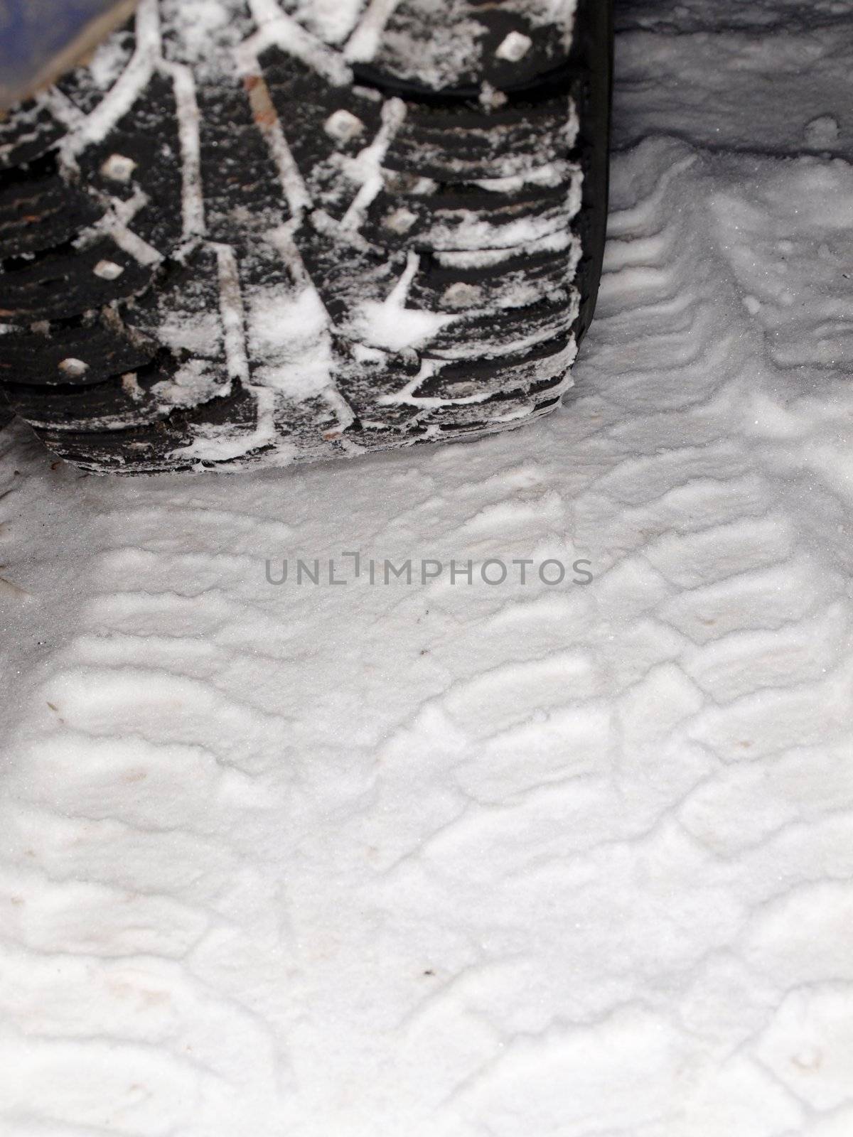 Studded winter tires, isolated on top of snow covered ground